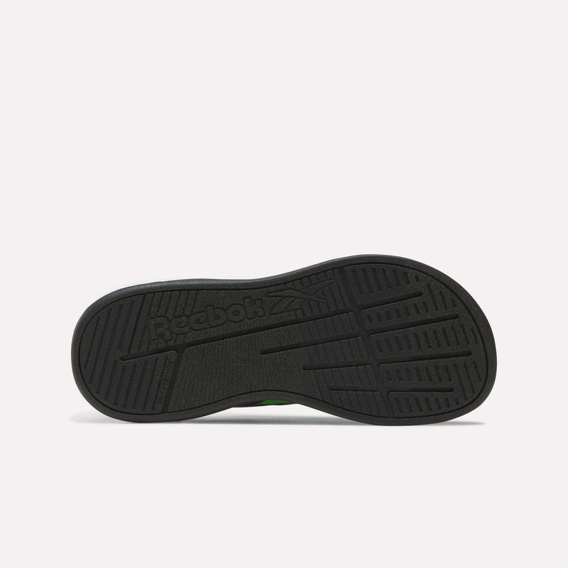 The image shows the black rubber sole of Reebok's Nano Play Slip-On Shoes for little kids, featuring the Reebok logo and textured grip patterns. The sole is flat against a plain light background.