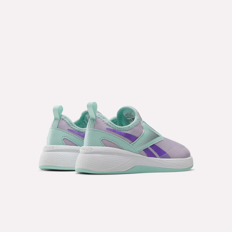 The Reebok Nano Play Slip-On Shoes for little kids feature a light purple, mint green, and teal design with mesh panels and a thick white sole. Shown angled away on a plain light background.