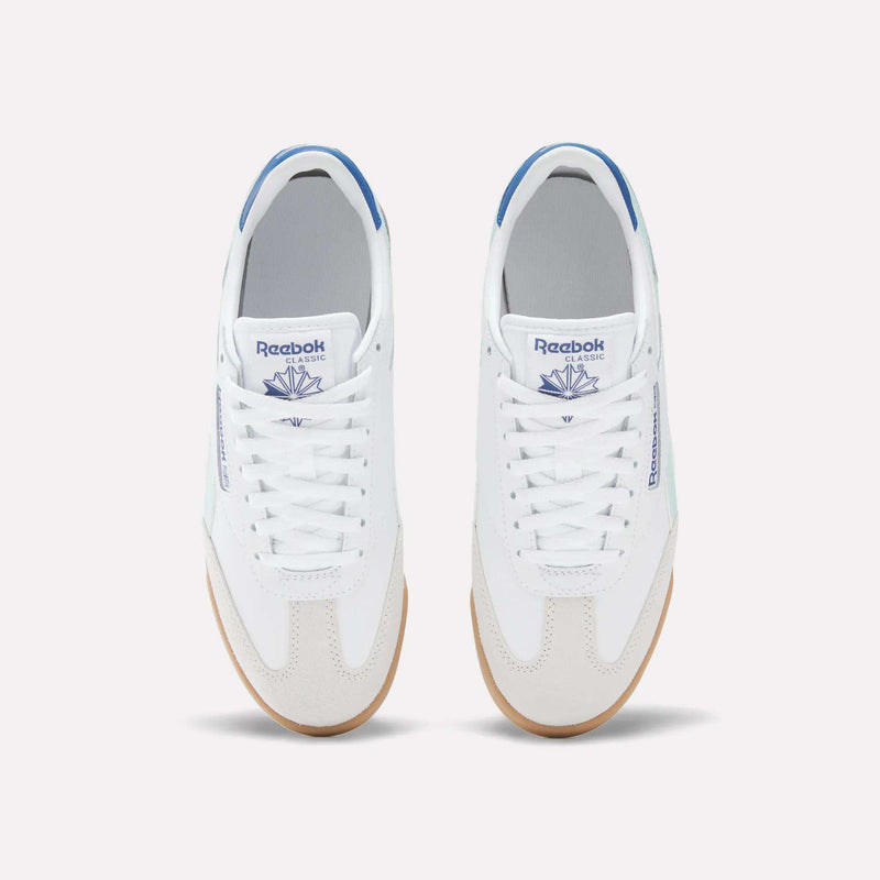 A pair of white Reebok Campio XT Shoes for Big Kids with blue accents, seen from above. These leather sneakers feature white laces, gum soles, and the blue Reebok logo on the tongue and side.