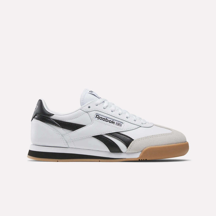 The Reebok Campio XT Shoes for big kids feature a white leather upper with black accents, a black Reebok logo, white laces, and a beige rubber sole, shown in side profile against a plain light background inspired by retro soccer style.