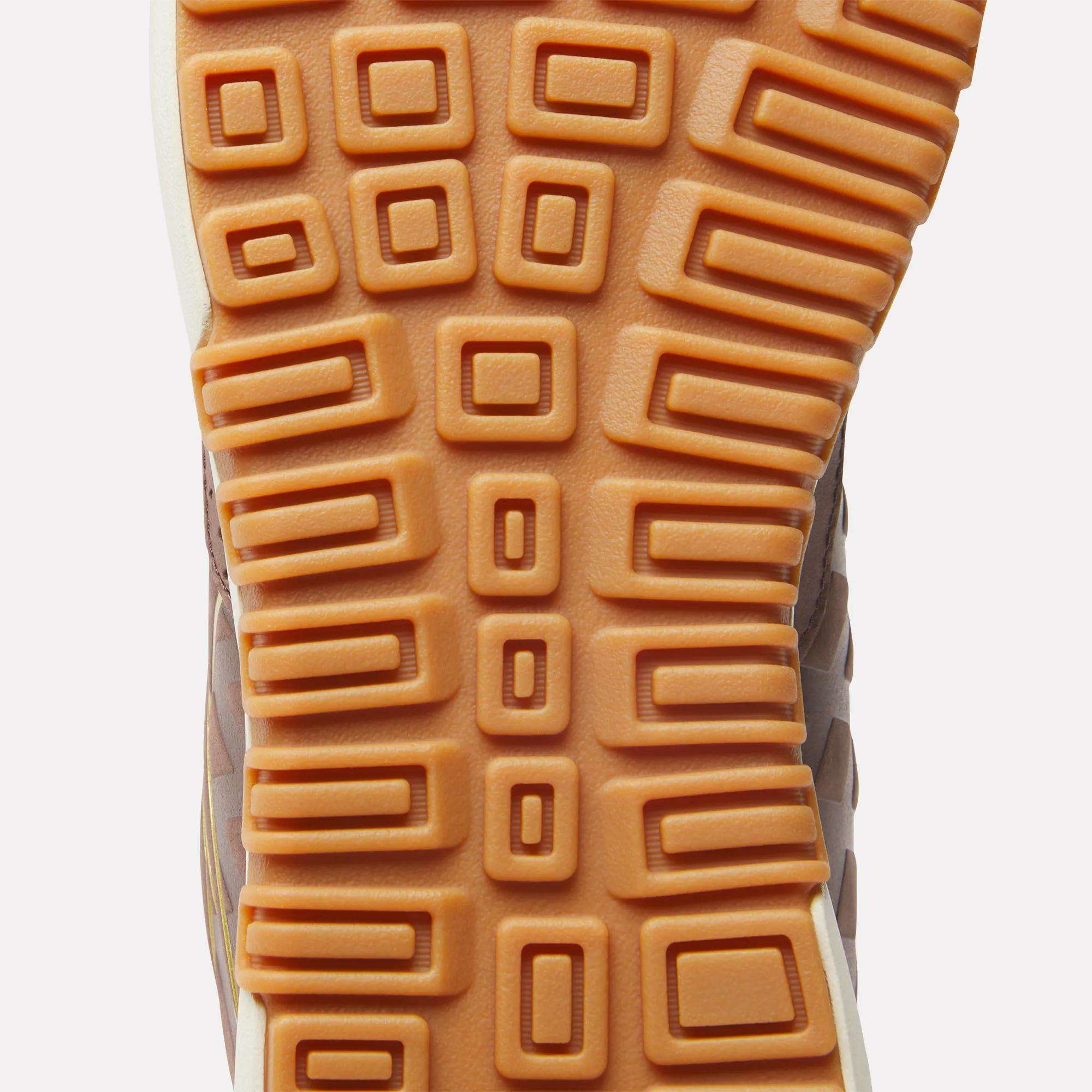 Close-up of the tread pattern on the sole of Reebok Nano 2.0 Training Shoes, showing orange rubber with square and rectangular raised sections in a geometric grid.