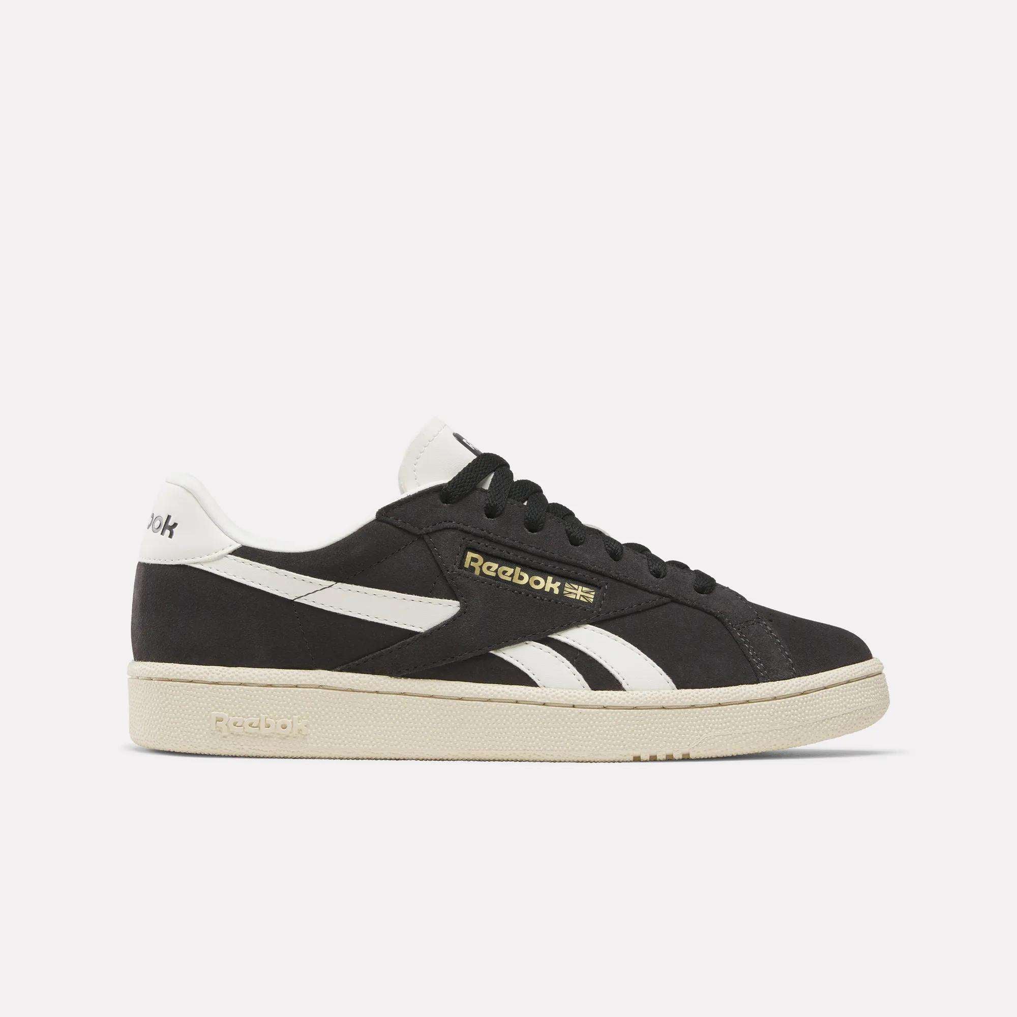 The Reebok Club C Ground UK Shoes feature a black suede upper, white accents, black laces, a beige sole, and metallic gold branding on the side, shown against a plain white background.