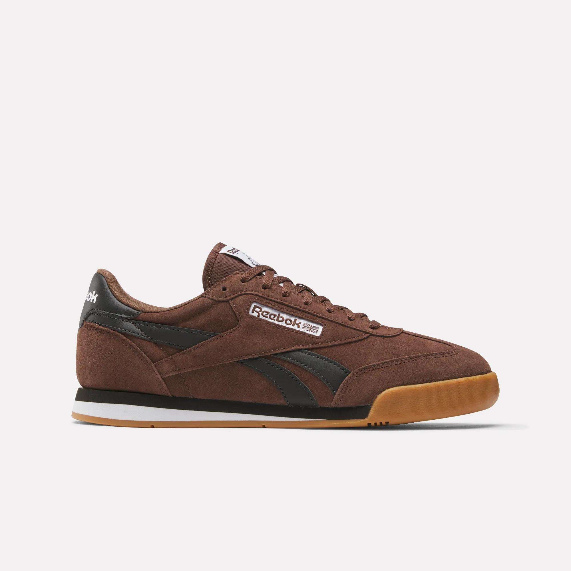 The Reebok Campio XT Shoes feature a brown upper with black accents, white side branding, a black heel tab, and gum rubber sole for '90s soccer style, shown against a plain white background.