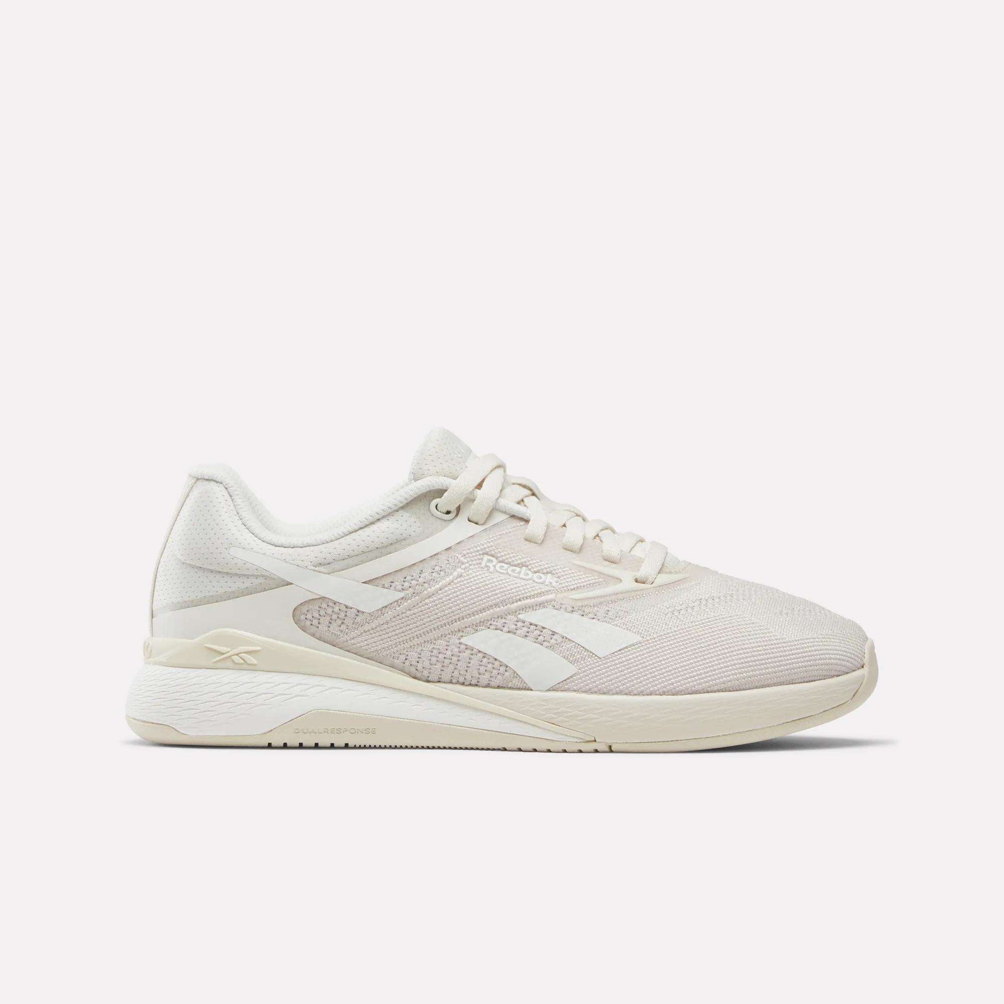 The Women's Nano X5 Training Shoes by Reebok are beige athletic sneakers with white accents, a mesh upper, and a thick cushioned sole, shown in side profile against a plain white background.