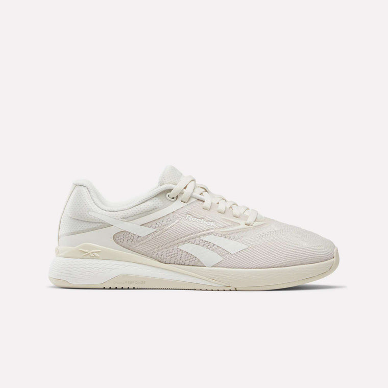 The Women's Nano X5 Training Shoes by Reebok are beige athletic sneakers with white accents, a mesh upper, and a thick cushioned sole, shown in side profile against a plain white background.