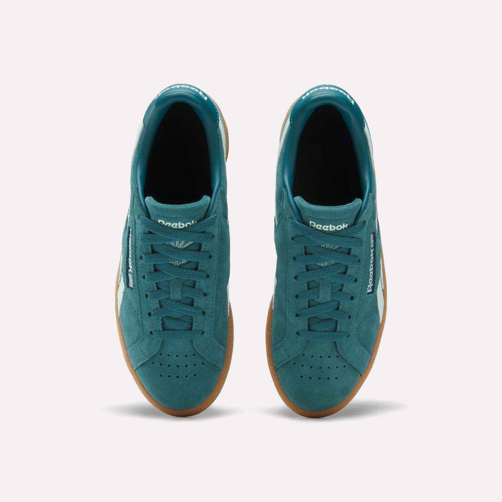 Top view of Women's Club C Grounds UK Shoes by Reebok in teal suede with gum soles, white side branding, and teal laces, displayed on a plain white background.