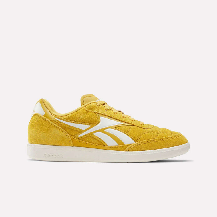 The Finale Shoes are yellow Reebok sneakers with white accents, a white side logo, yellow laces, and a white sole. Inspired by Reebok heritage retro sport shoes, these suede sneakers are displayed against a plain white background.