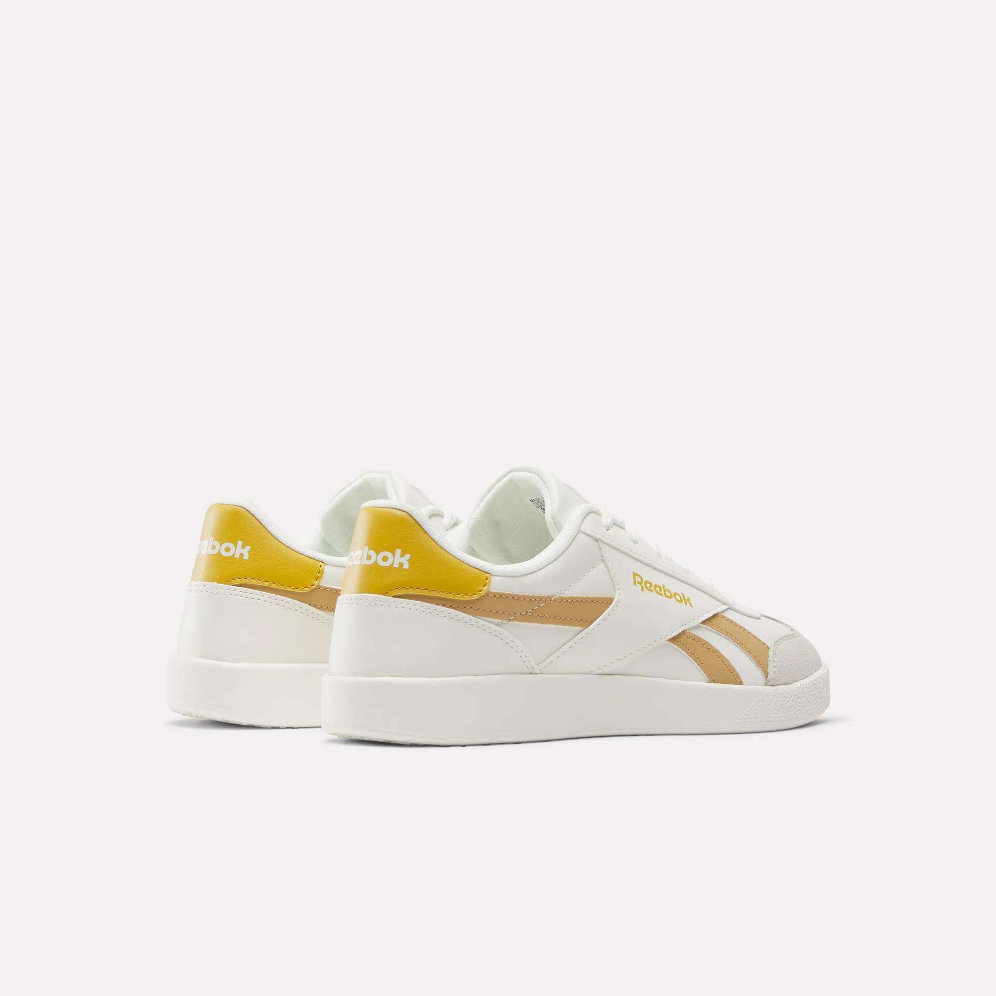 Reebok Smash Edge Shoes in white with yellow accents and beige stripes—ideal for indoor soccer. Displayed from the back and side on a plain white background.