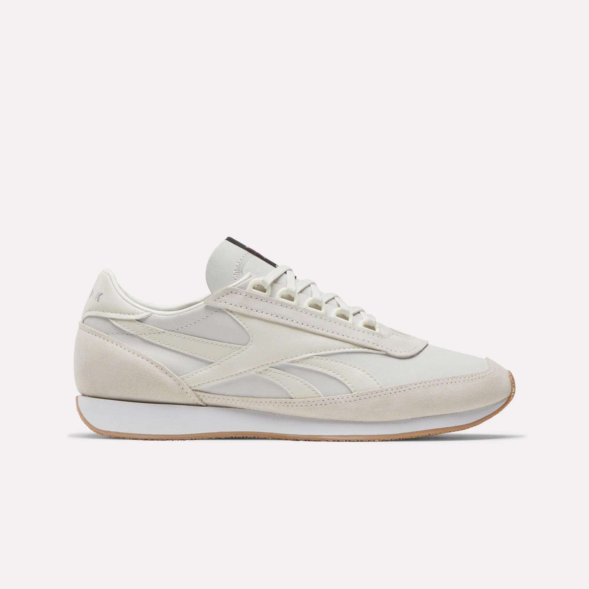 A side view of Reebok Camargue Shoes in white and beige showcases a low-profile, lace-up design with a slightly raised sole, subtle stitching, and minimalist detailing for timeless style.