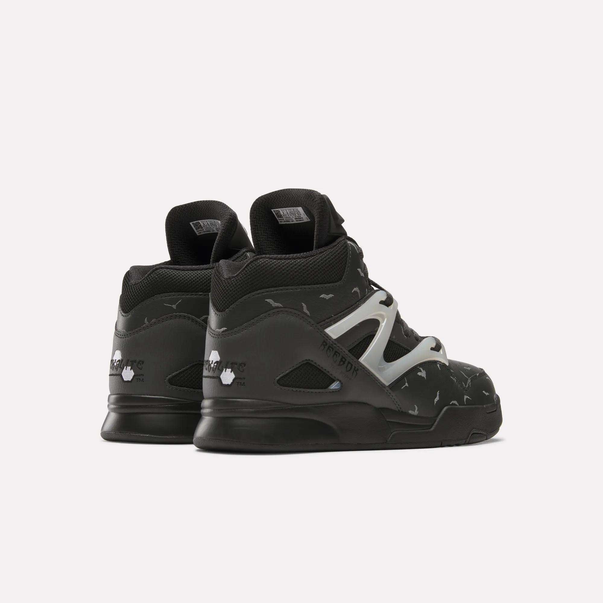 A pair of black Reebok Pump Omni Zone II Retro Basketball Shoes, high-top leather design with white side detail and small reflective accents, displayed from the back and side on a plain white background.