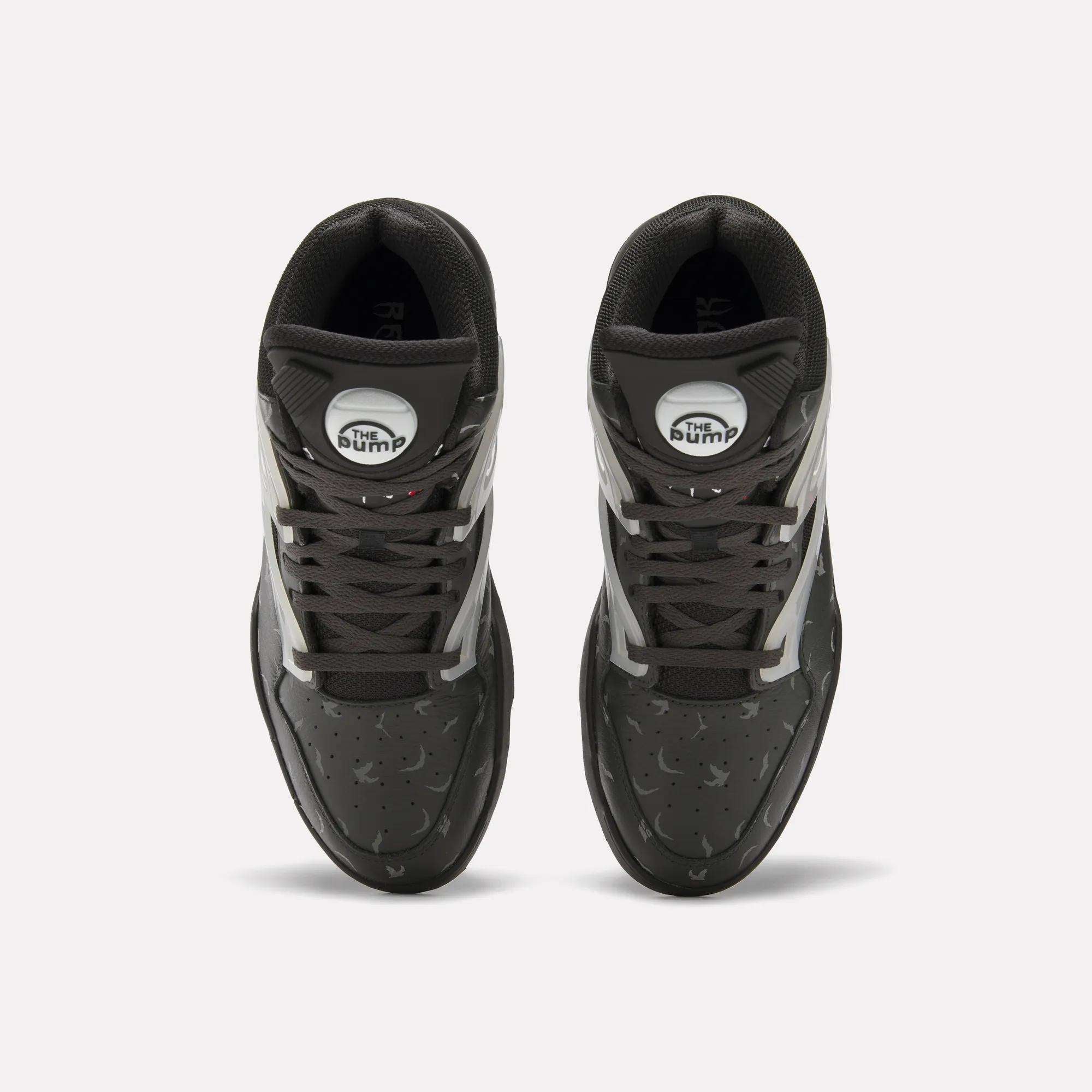 Top view of Reebok Pump Omni Zone II Retro Basketball Shoes with black uppers, white and reflective accents, dark gray laces, and white circular Pump patches on the tongues. The textured surface features small perforations.