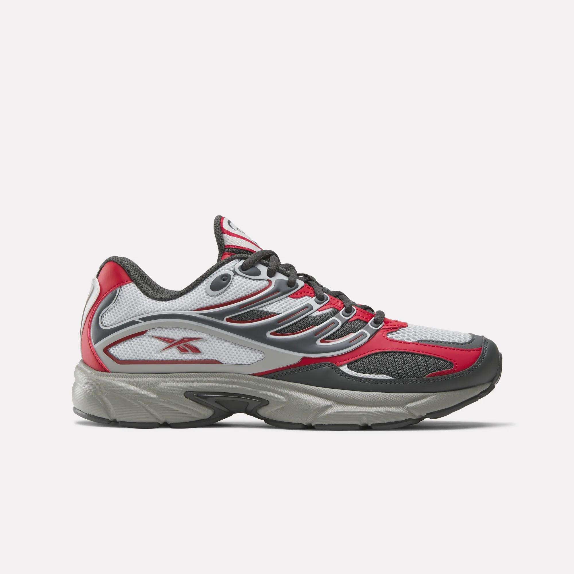 The Reebok Premier Road Control Shoes are shown in a side profile on a plain white background, featuring red, white, and gray colors with black accents, mesh panels, and the signature Reebok logo on the side.