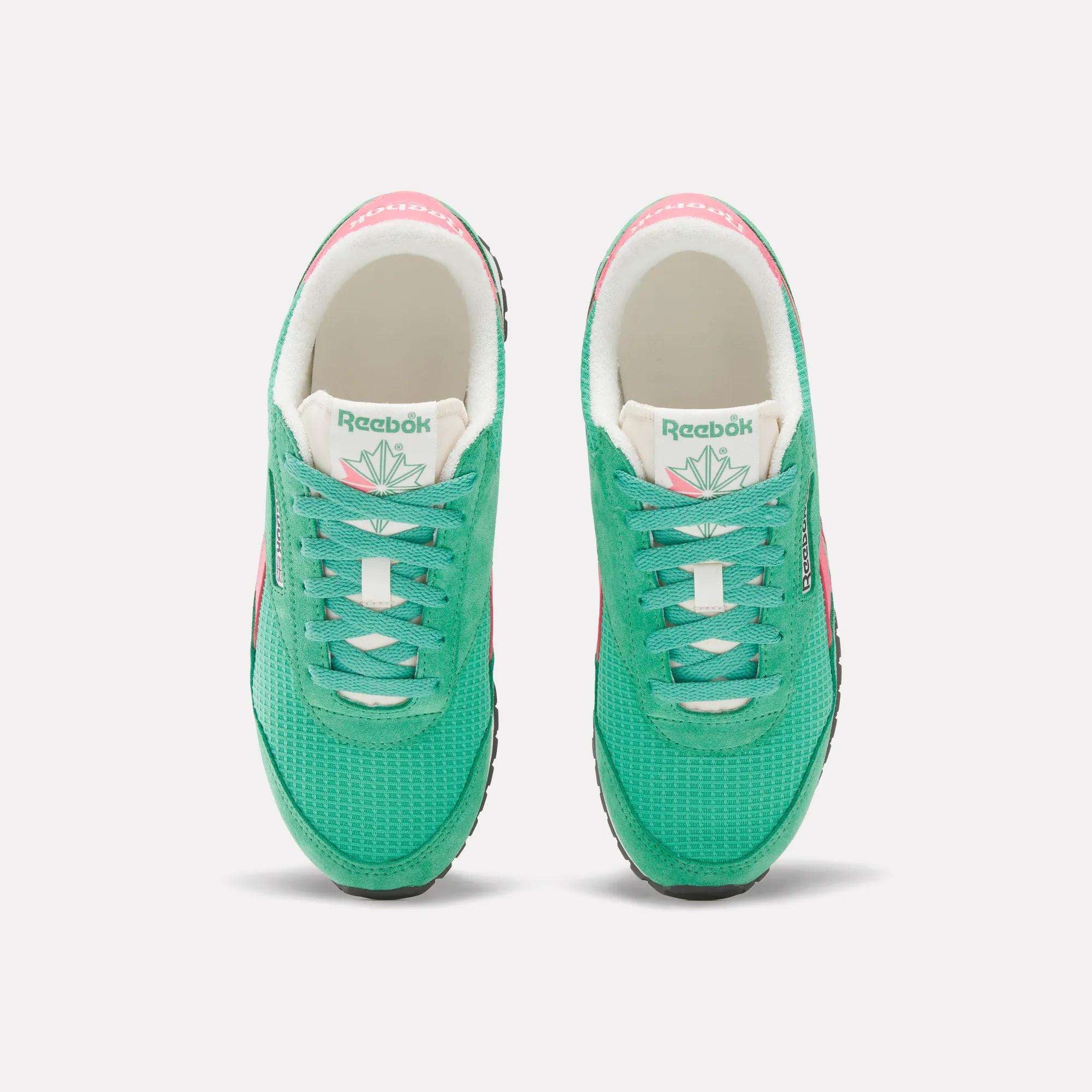 A top view of Reebok Women's Classic AZ Shoes in green, featuring white tongues, black soles, and pink accents on the sides and heels—an ideal pick for retro running shoe fans, displayed against a plain white background.