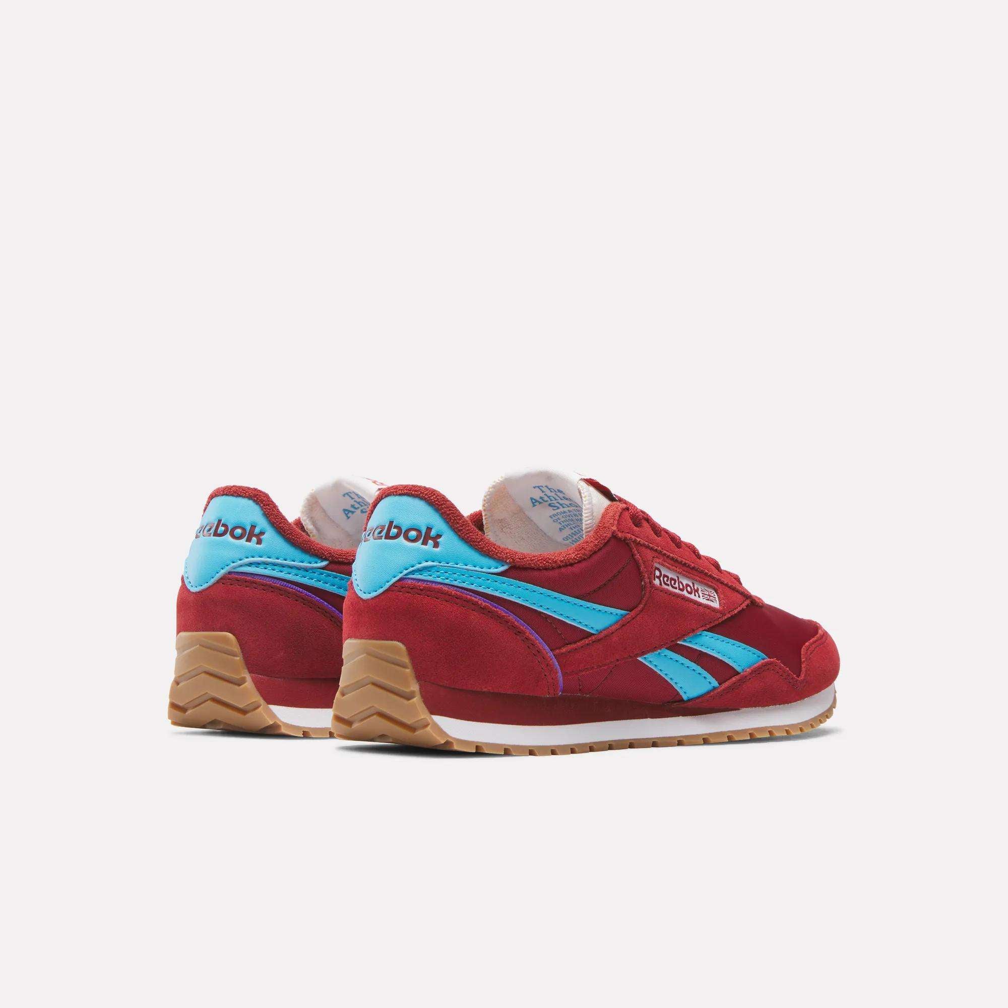 The Reebok Women's Classic AZ Shoes in red with blue accents and gum soles are displayed from the back and side, highlighting their vintage-inspired design against a plain white background.