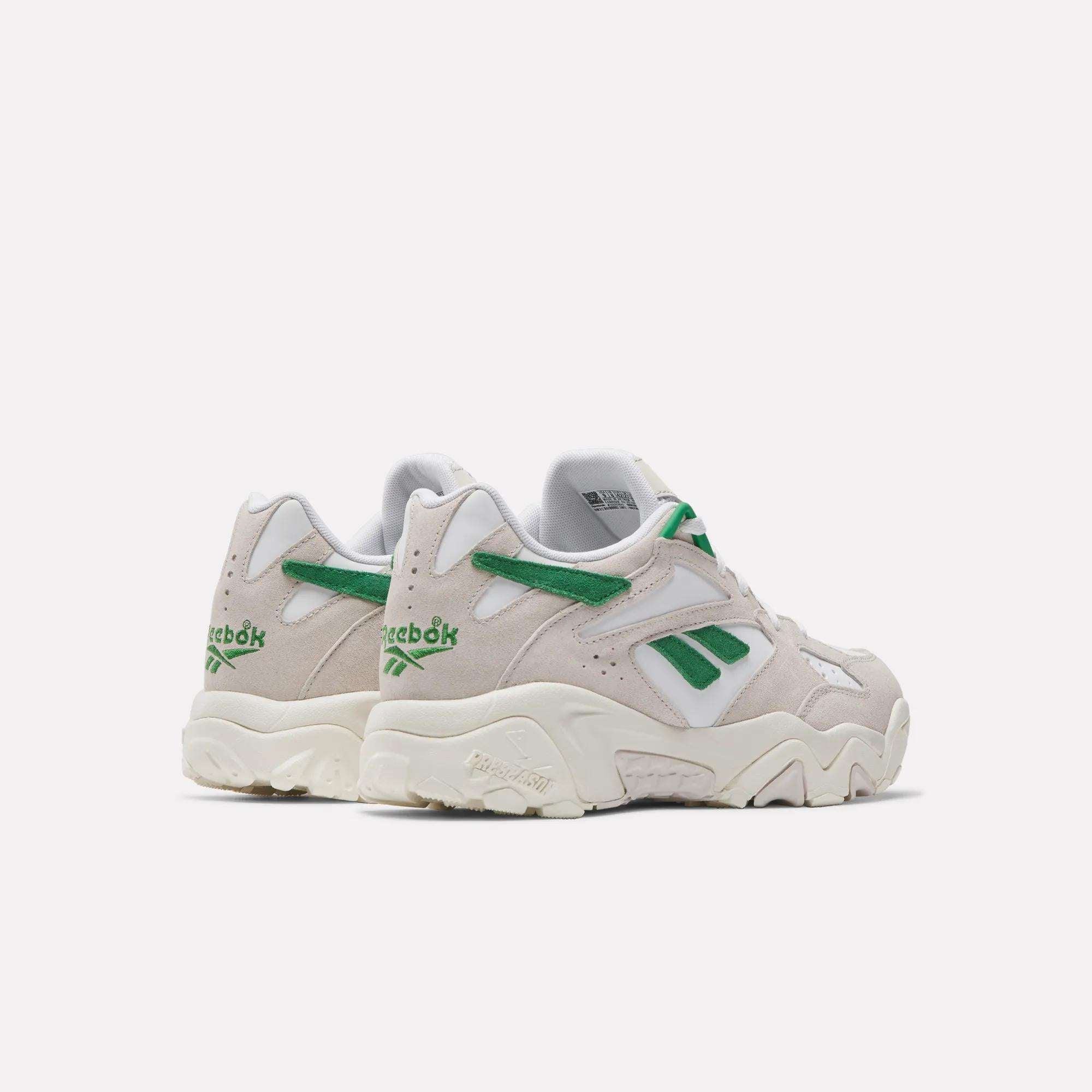 A pair of Reebok Preseason 94 Low Retro Basketball Shoes in light beige with green and white accents, viewed from the back and side, featuring the Reebok logo and chunky off-white soles inspired by '90s training styles.