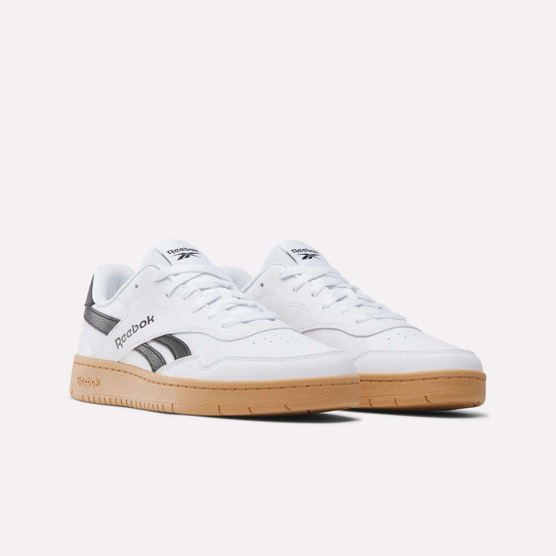 The Reebok BB 1000 Shoes are shown on a plain white background, featuring a white leather upper with black accents and gum rubber soles that pay tribute to classic ’80s heritage.