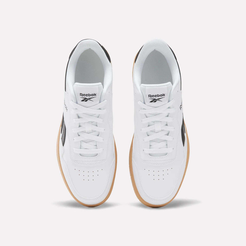 A pair of BB 1000 Shoes by Reebok with a white leather upper and gum soles, seen from above. These sneakers feature black accents, white laces, and the Reebok logo on the tongues and sides, highlighting classic ’80s heritage style.