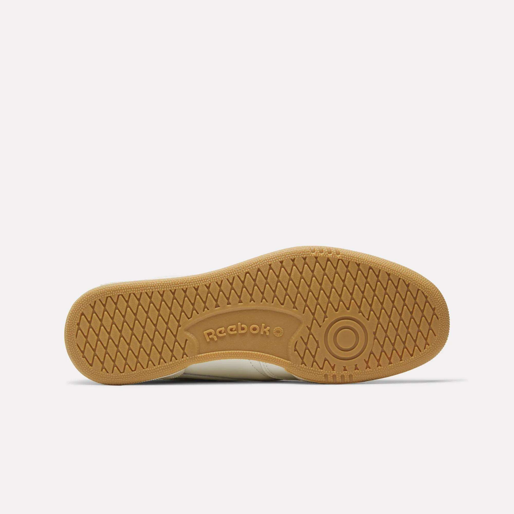 The image shows the gum rubber outsole of the Reebok Club C 85 Vintage Shoes, featuring a herringbone tread, circular toe design, and Reebok branding at the center.