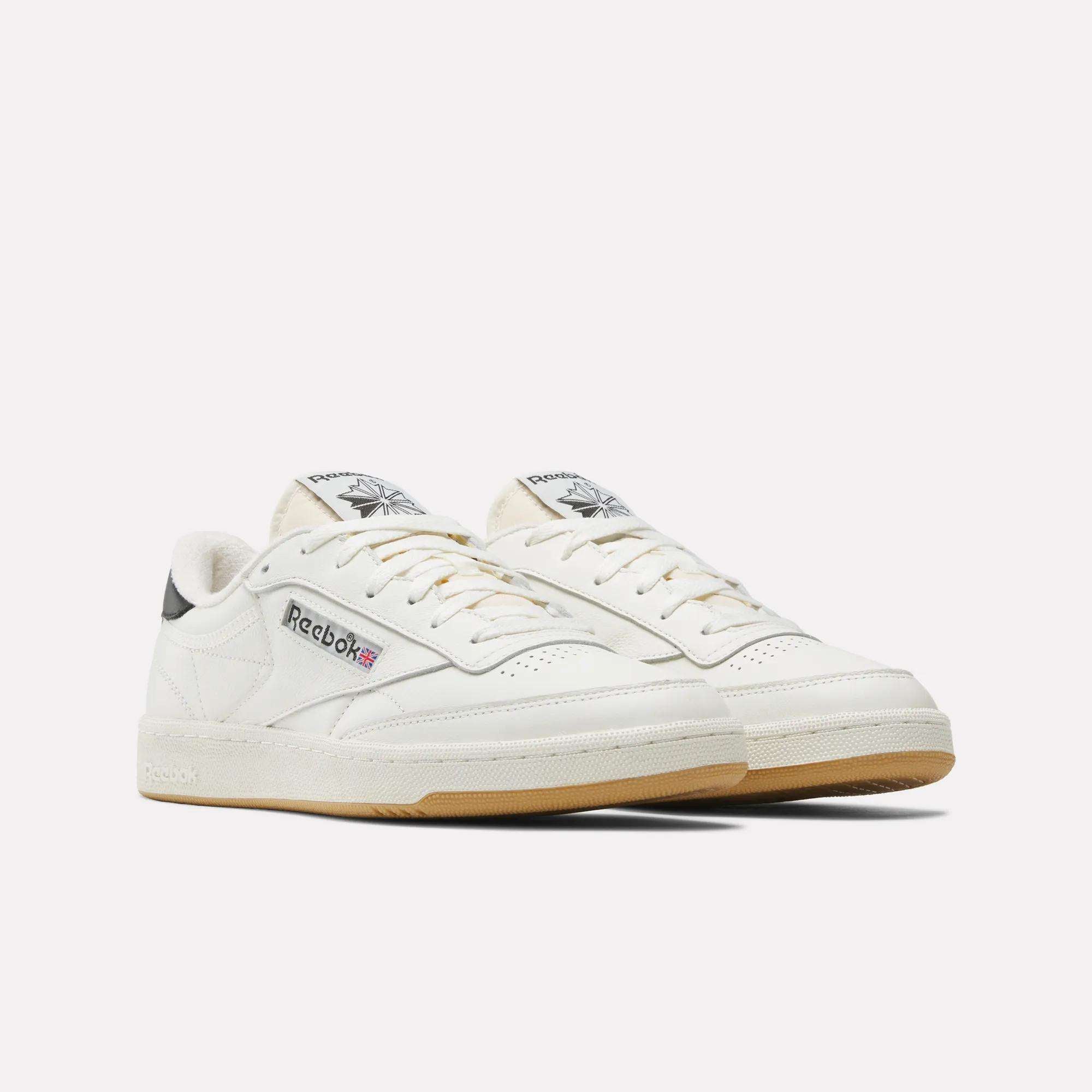 A pair of off-white Reebok Club C 85 Vintage Shoes with a leather upper, gum soles, black heel accents, and Reebok logos on the side and tongue, shown on a plain white background.