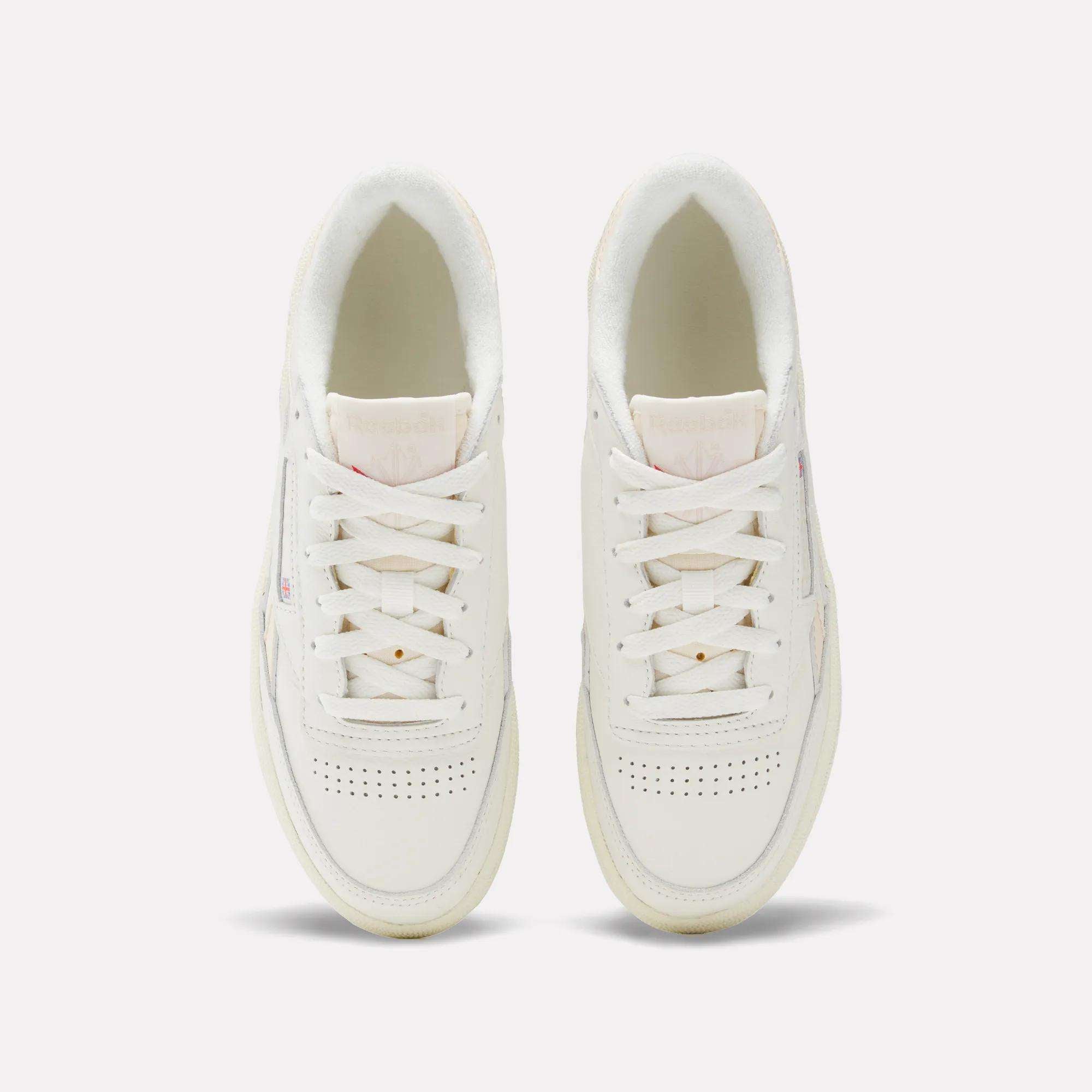 Top view of Reebok Women's Club C Revenge Vintage Shoes with white laces, perforated toe details, and light pink and beige accents on a plain light background—combining vintage style with modern comfort.