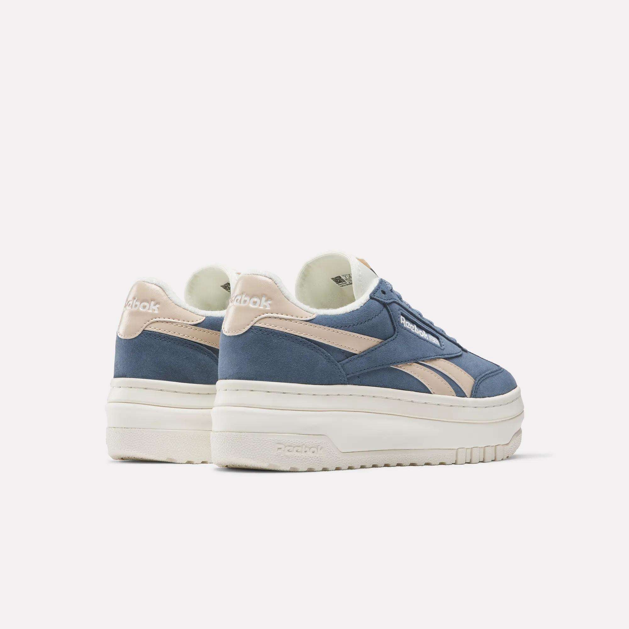The Reebok Campio Extra Women's Shoes feature blue suede uppers, beige accents, and a chunky platform midsole. Displayed on a light background, the pair is positioned facing slightly away from each other.