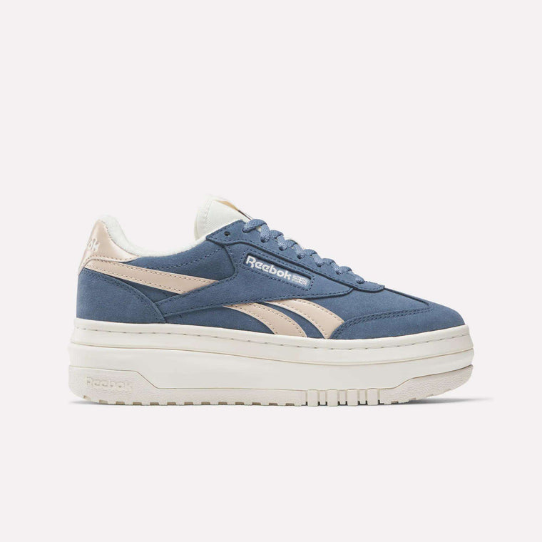 The Reebok Campio Extra Women's Shoes feature a blue and beige design with beige stripes, blue laces, chunky white platform midsole, and a side Reebok logo, shown in a side profile on a plain white background.