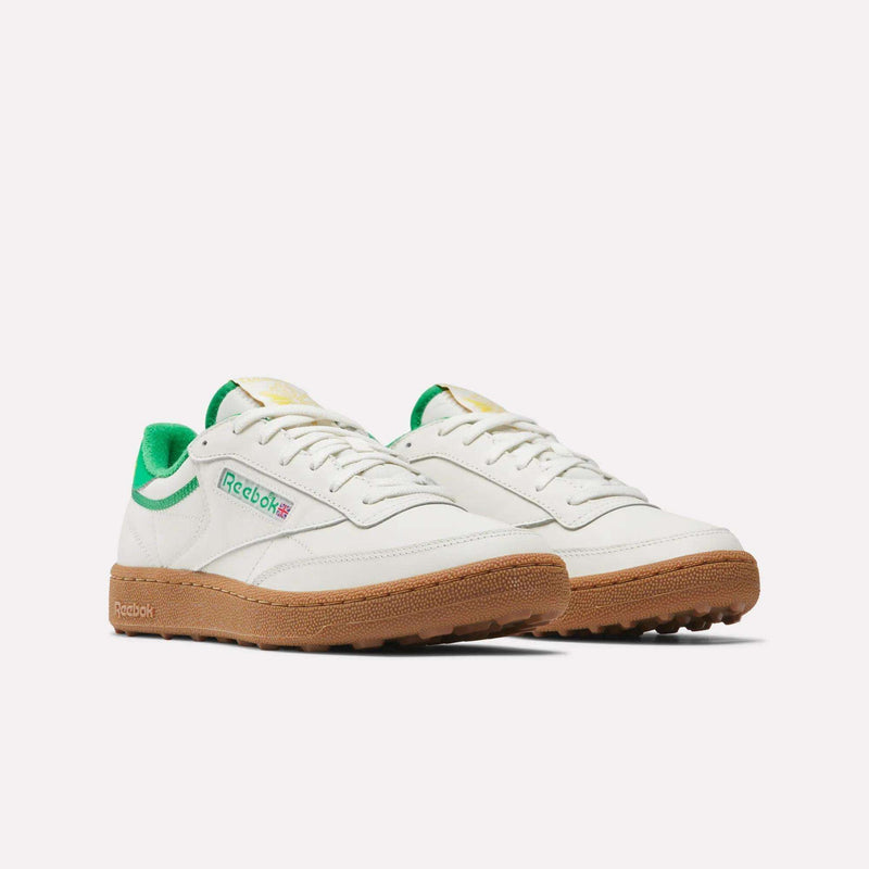 Men's Club C Golf Shoes by Reebok in white with green accents, a gum rubber spikeless outsole, and the Reebok logo on the side, shown against a plain white background.