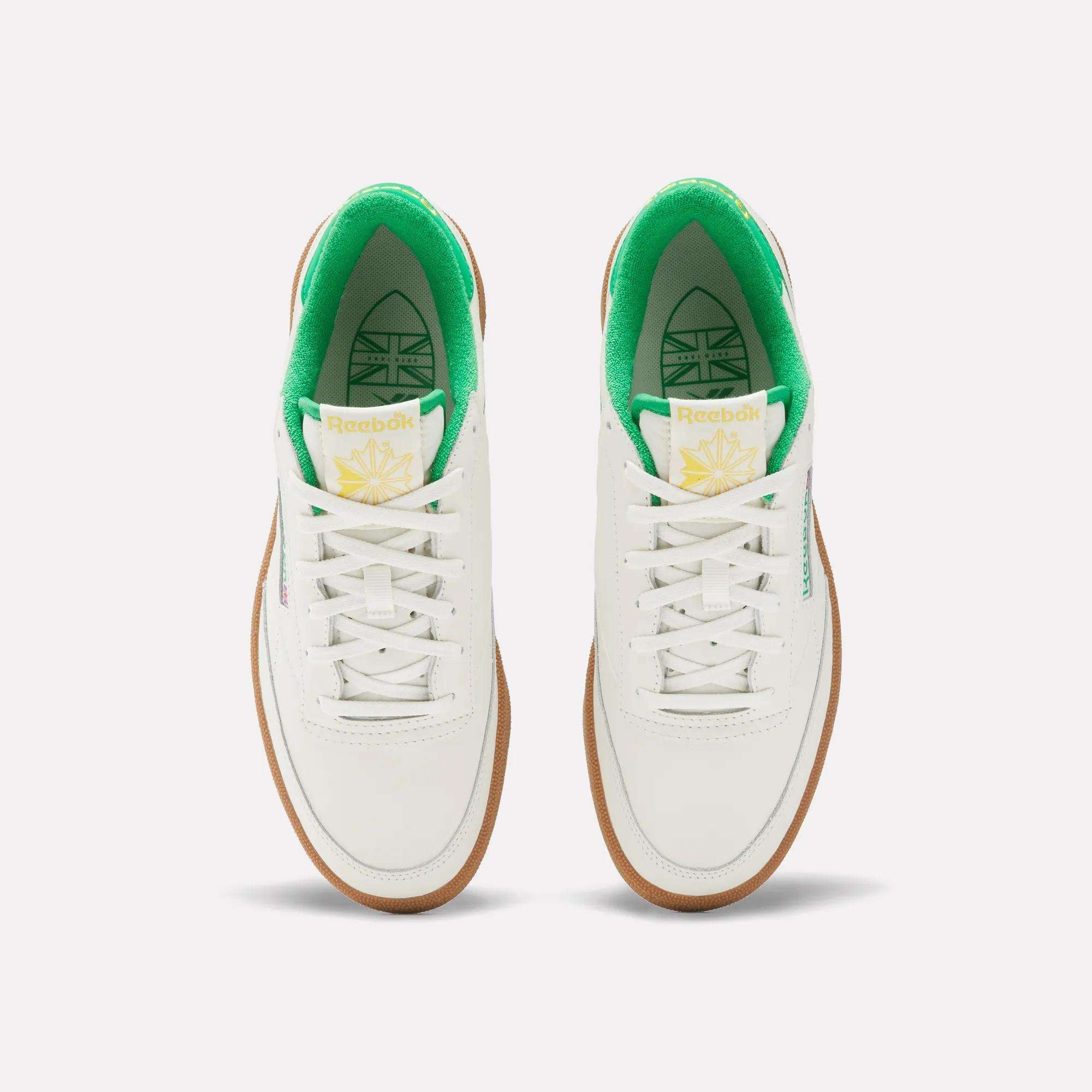 The Reebok Men's Club C Golf Shoes feature a white, water-resistant leather upper, green inner lining, white laces, gum soles, spikeless outsole, and yellow-green tongue branding—shown from above on a plain background.