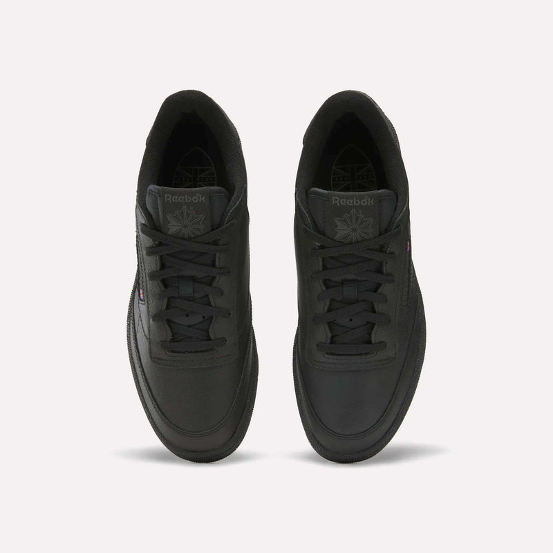 A pair of Reebok Men's Club C Golf Shoes in black with laces, a tongue displaying the Reebok logo, low-top silhouette, and spikeless outsole, shown from above on a plain white background.