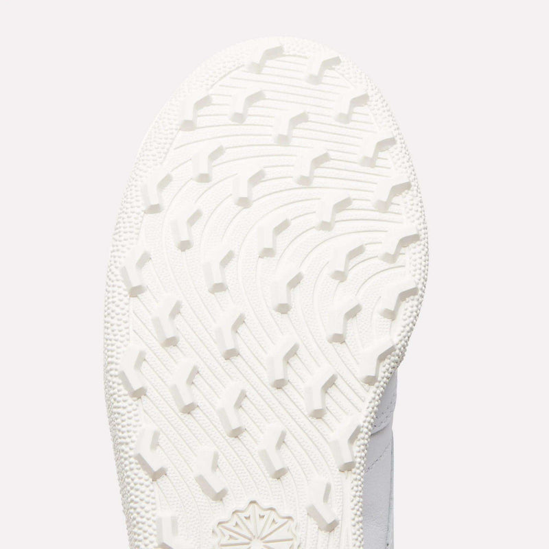 Close-up of the white sole on Reebok Women's Club C Golf Shoes, showing a curved, textured tread with raised angular grips on its spikeless outsole.