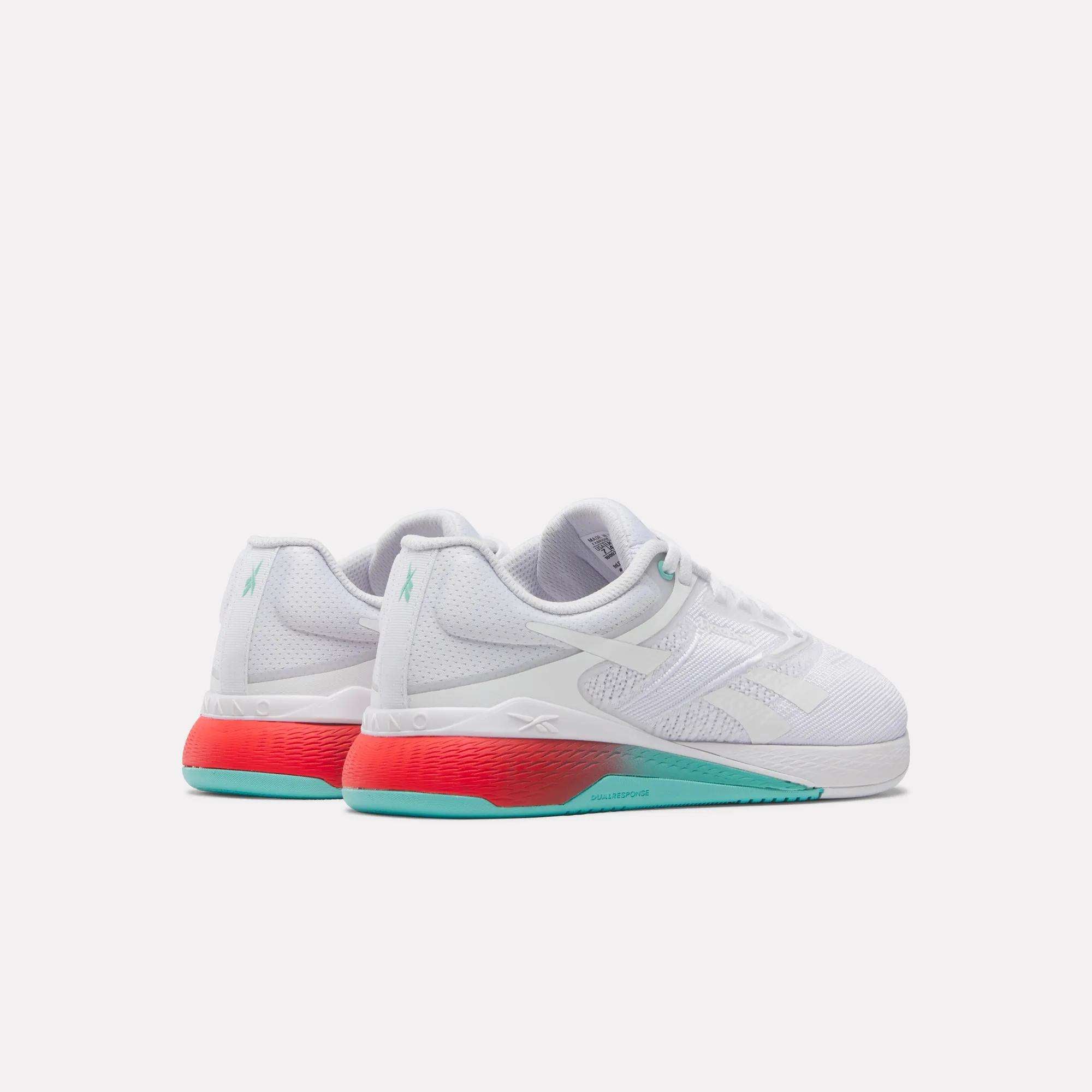 The Women's Nano X5 Training Shoes by Reebok are comfortable white trainers with light gray accents, gradient red midsoles, and teal outsoles, shown on a plain white background.