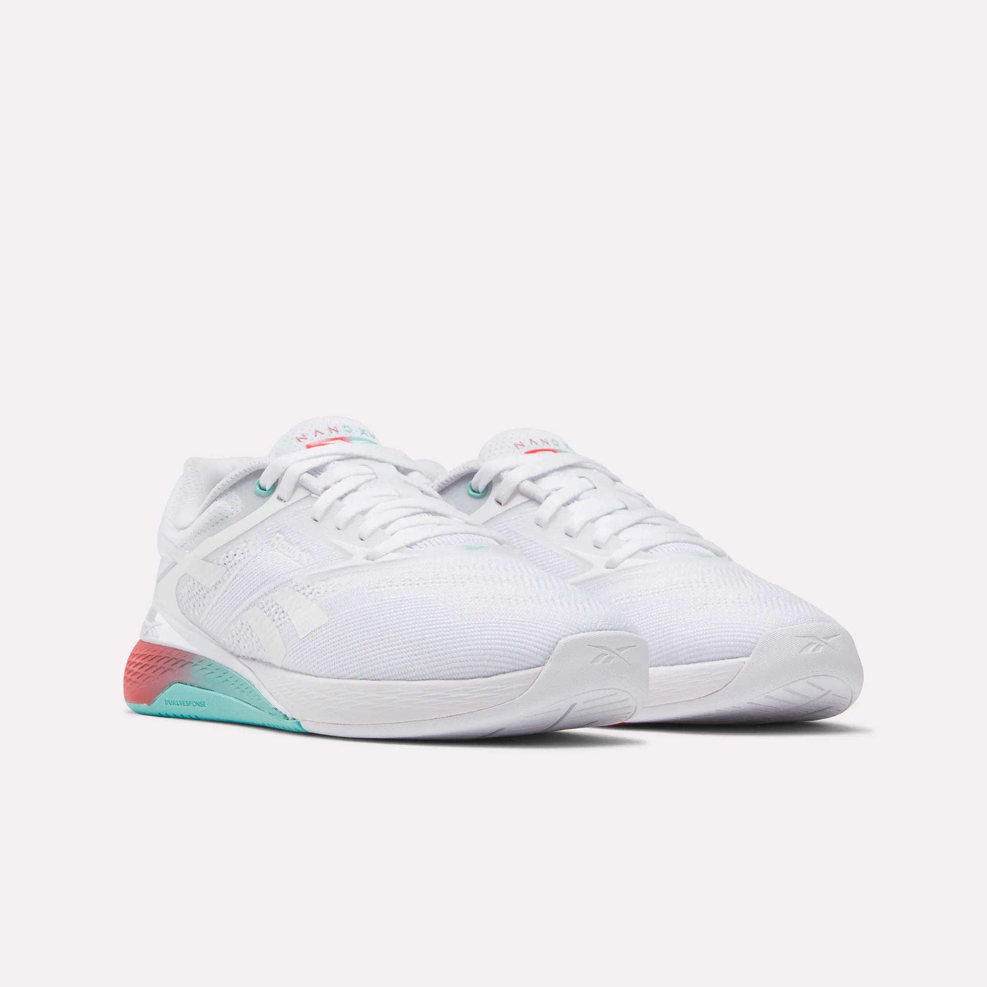 The Reebok Women's Nano X5 Training Shoes are comfortable white athletic sneakers with teal and pink accents on the sole and heel, shown side by side on a plain white background—ideal for any workout.