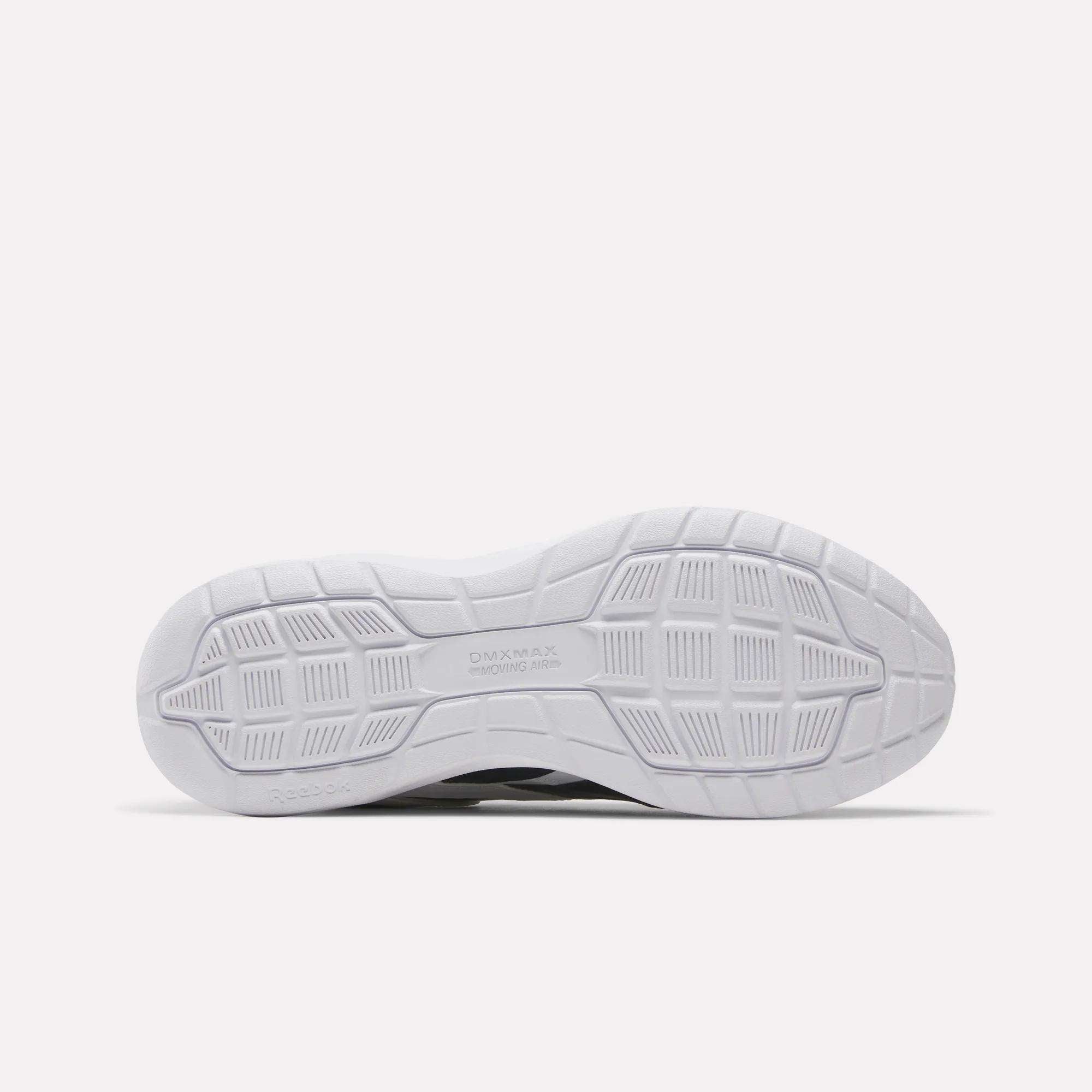 The image shows the white outsole of the Reebok Men's Walk Ultra 7 DMX Max Wide 4E Shoes, featuring a textured geometric tread with grooves, squares, and rectangles for grip. The DMX MAX branding appears near the center.