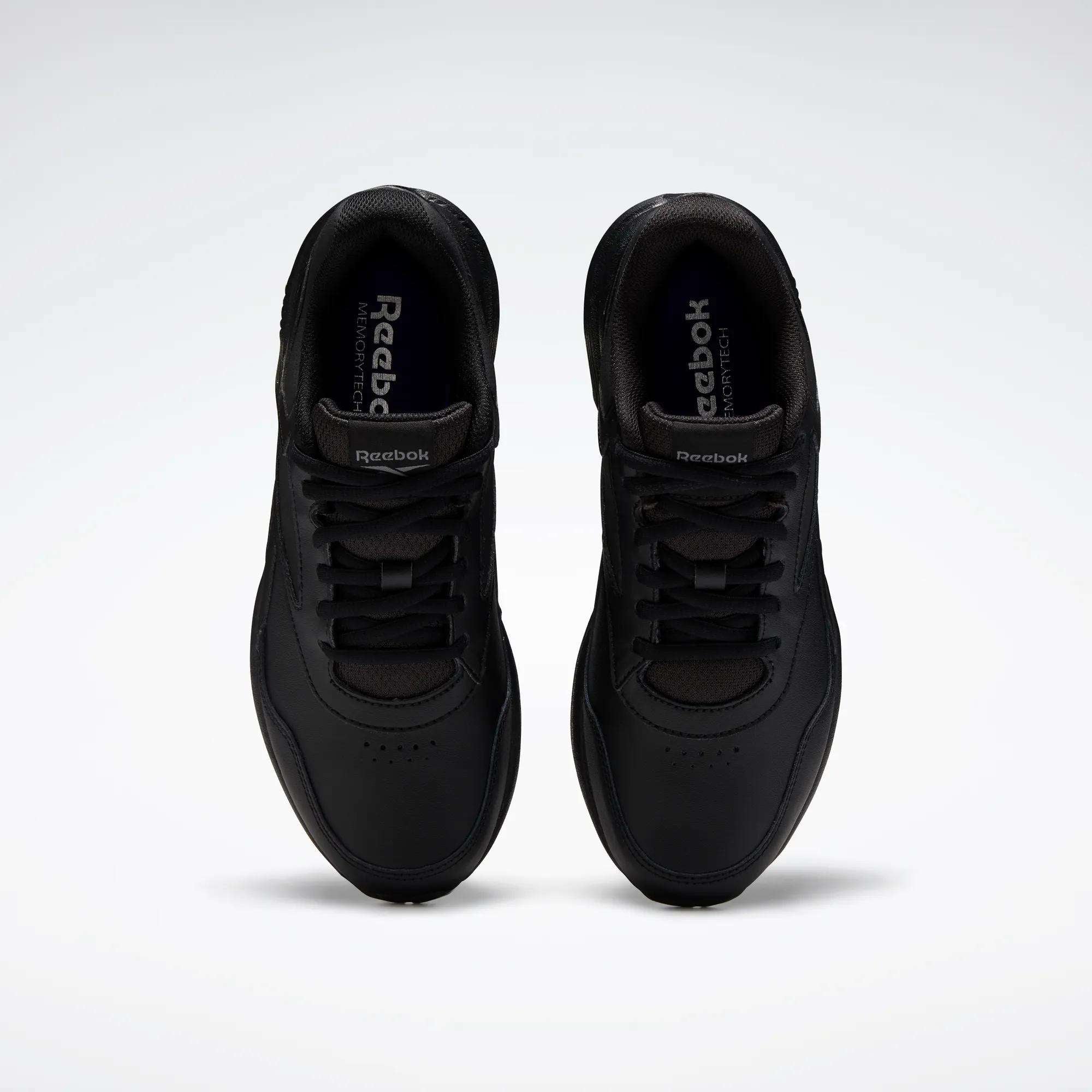 A pair of Women's Walk Ultra 7 DMX Max Walking Shoes by Reebok, shown from above with black laces and a minimalist design featuring DMX cushioning for comfort, set against a plain white background.