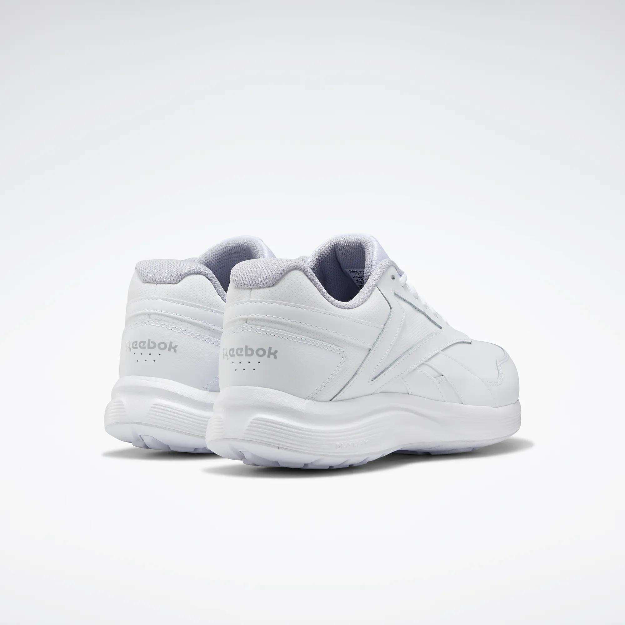 The Reebok Women's Walk Ultra 7 DMX Max Walking Shoes are displayed all in white on a light background, with one shoe slightly ahead to show both the side and back views. These walking shoes offer DMX cushioning for all-day comfort.