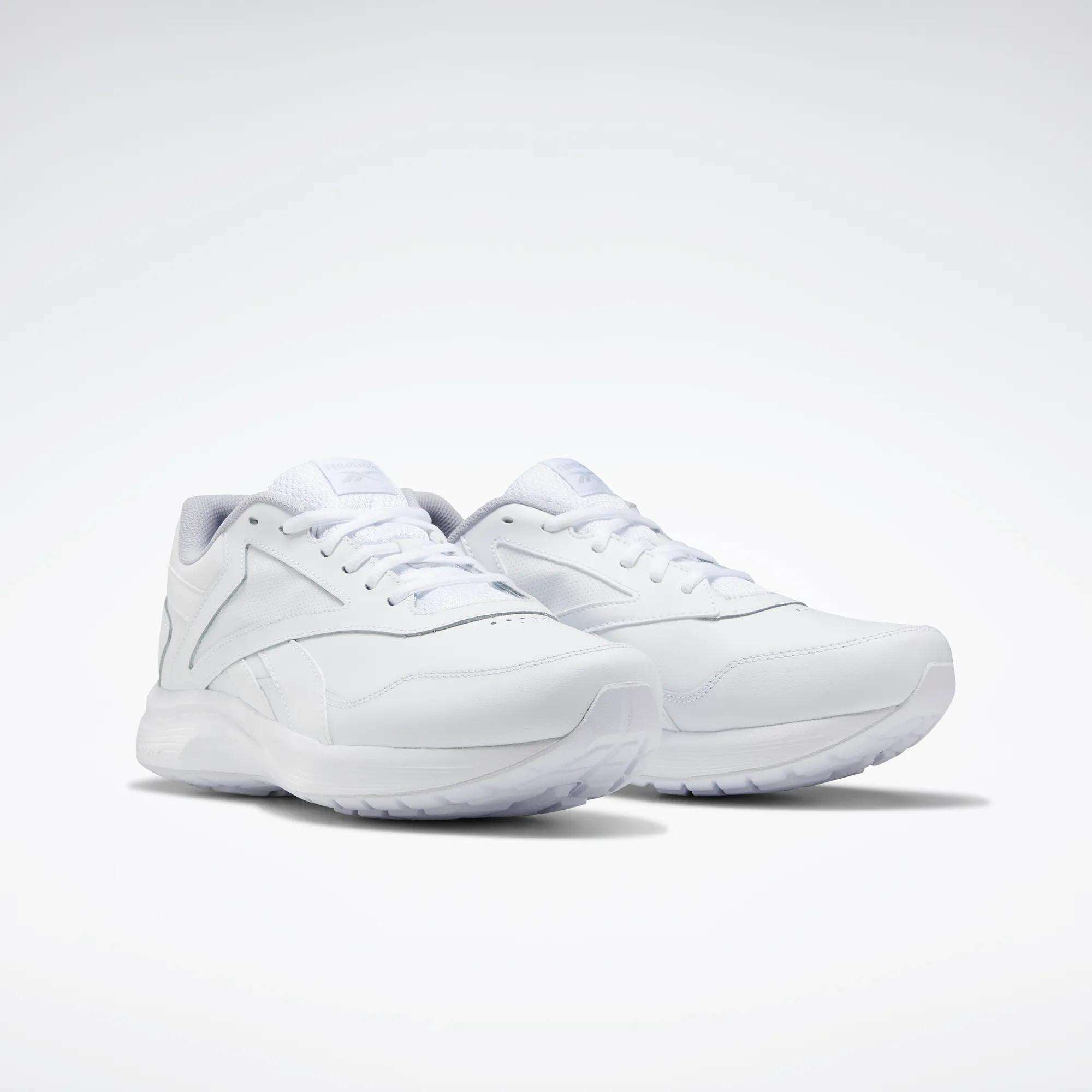 The Reebok Women's Walk Ultra 7 DMX Max Walking Shoes are shown in white on a light background, featuring a sleek minimalist design, white laces, DMX cushioned textured sole, and subtle stitched detailing.
