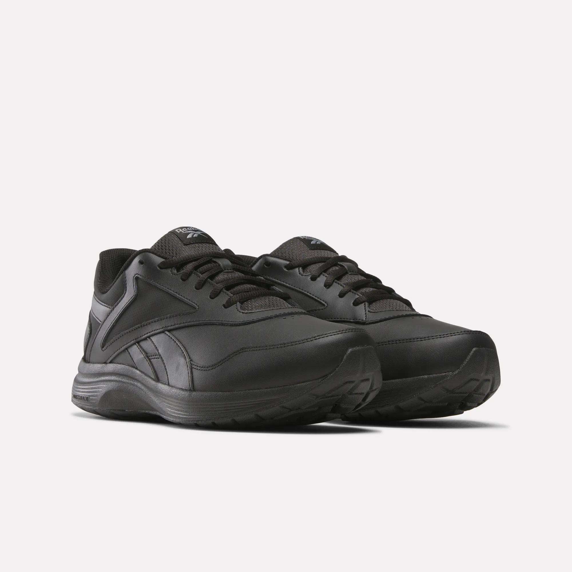 The Reebok Walk Ultra 7 DMX Max Walking Shoes, in black with lace-up closures, DMX cushioning, textured soles, and subtle logo details on the tongue and side, are displayed against a plain white background.