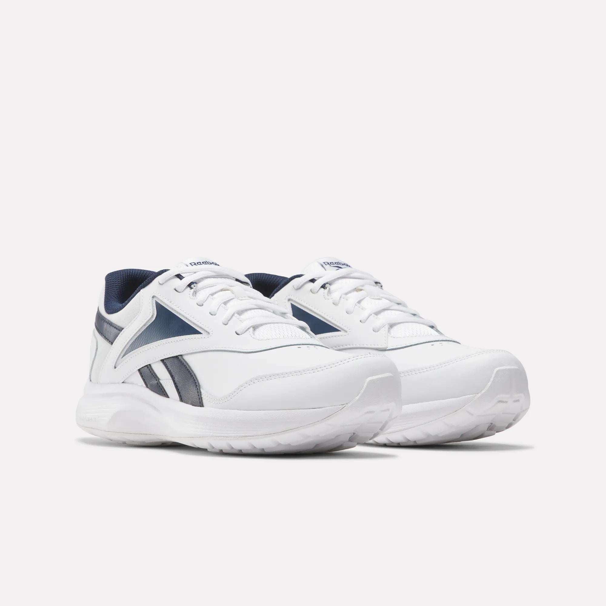 The Reebok Walk Ultra 7 DMX Max Walking Shoes feature white uppers with navy accents, breathable mesh panels, and a bold side logo, shown against a plain white background.