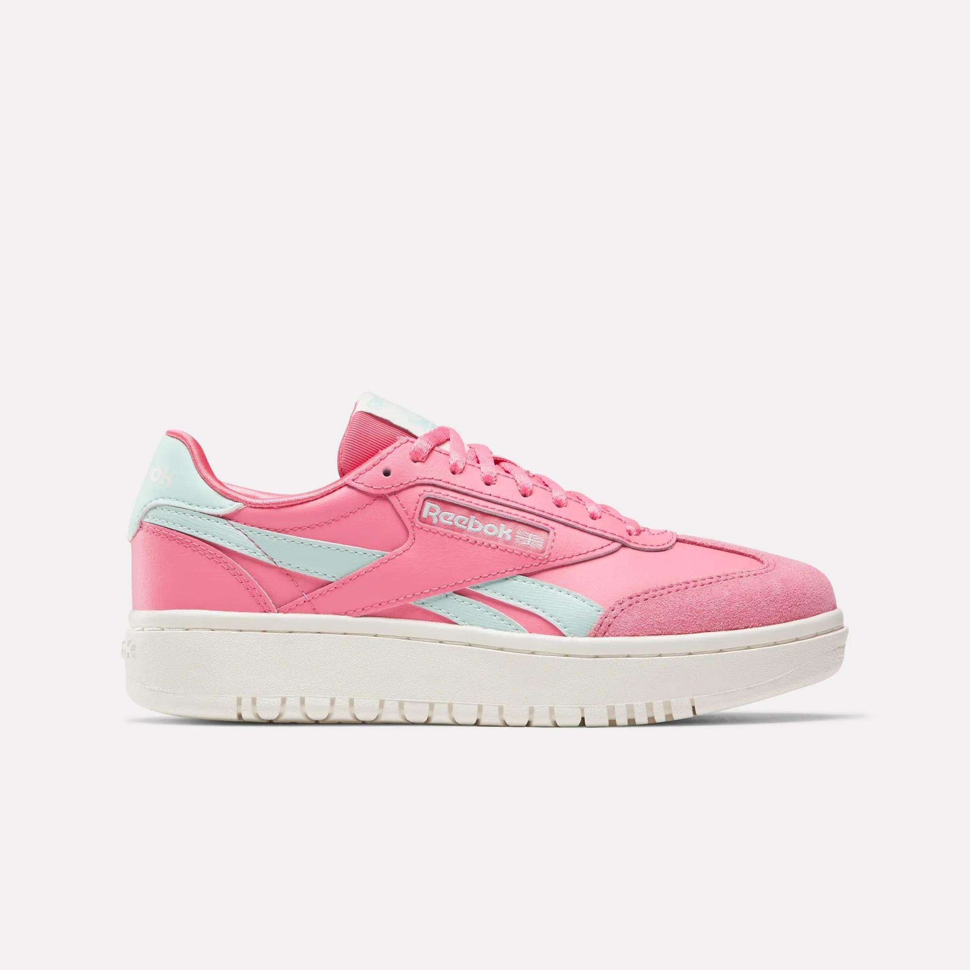 The Reebok Campio XT Double Shoes for big kids feature a pink design with light blue accents and a white sole, shown in a side view—ideal retro sneakers for girls seeking stylish Reebok footwear.