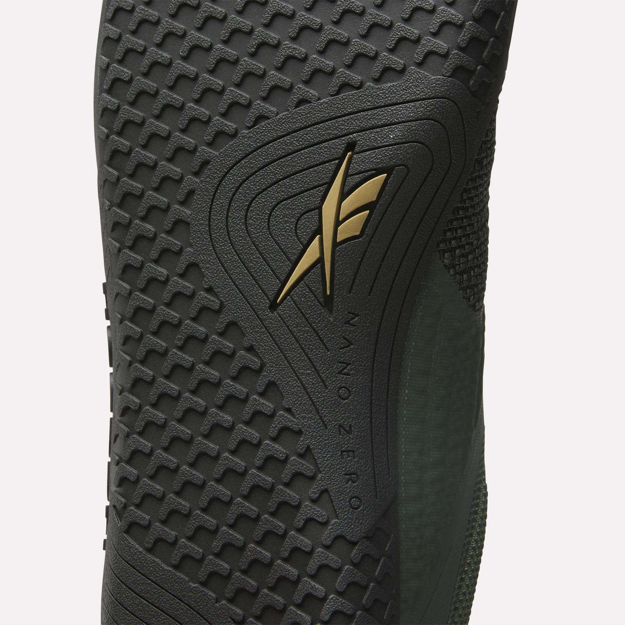 Close-up of the Reebok Nano Zero Training Shoes’ textured black sole with gold logo and "NANO ZERO" embossed. The zero-drop design features a mix of geometric patterns.