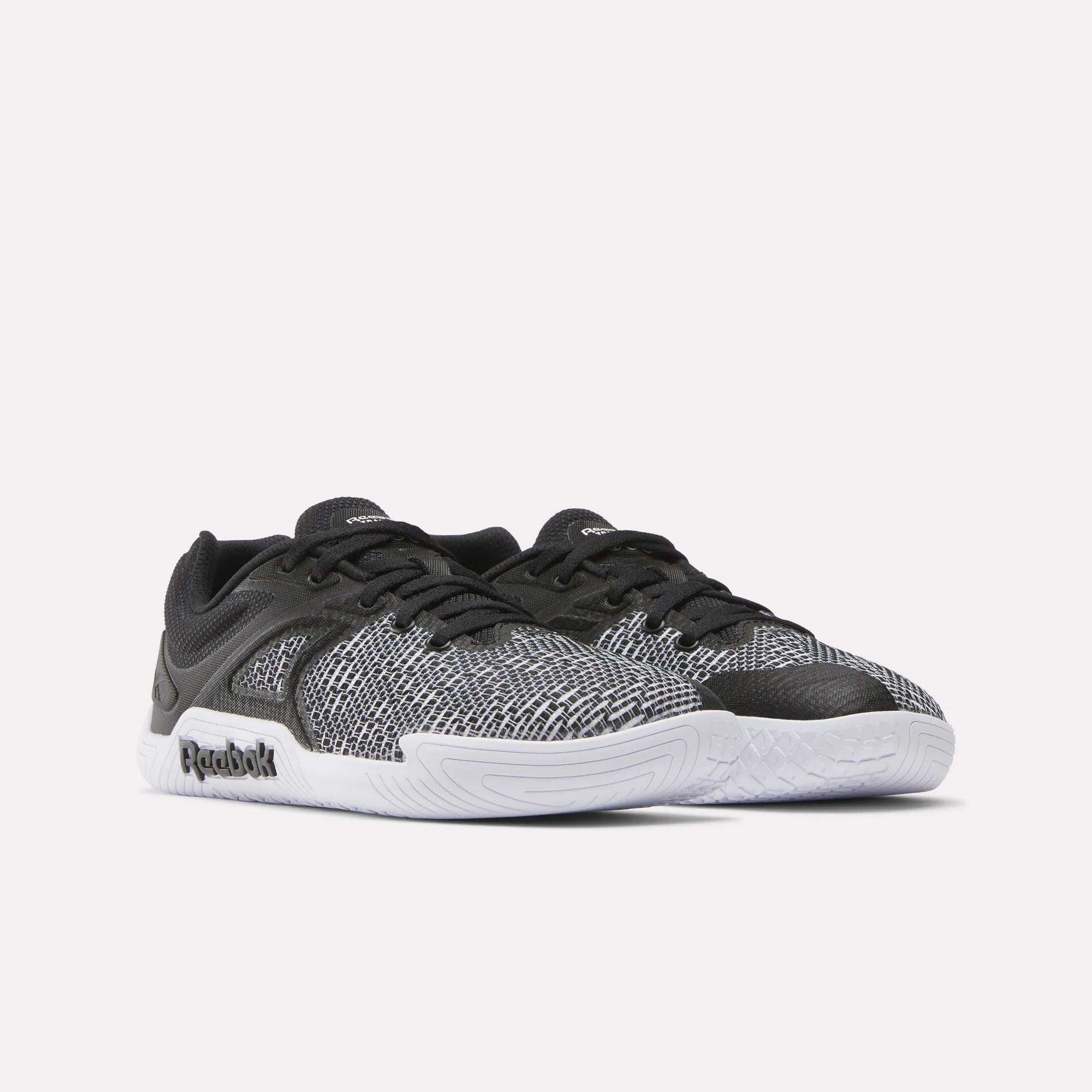The Reebok Women's Nano Zero Training Shoes feature black and white patterned mesh uppers, black laces, and white rubber soles—perfect for strength training—shown on a plain white background.