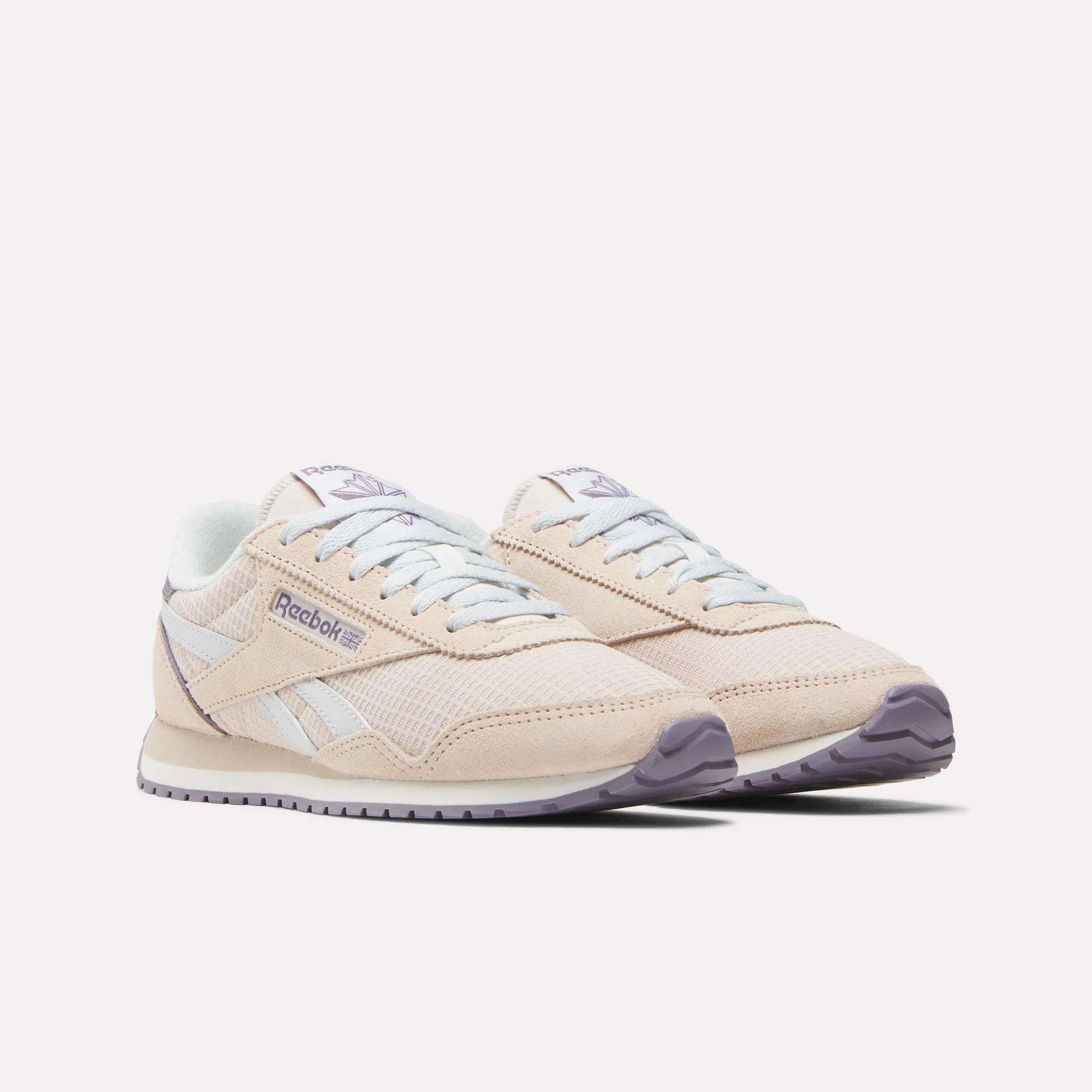 The Women's Classic AZ Shoes by Reebok are beige with white accents, a light purple outsole, and classic branding on the side and tongue, shown against a white background.