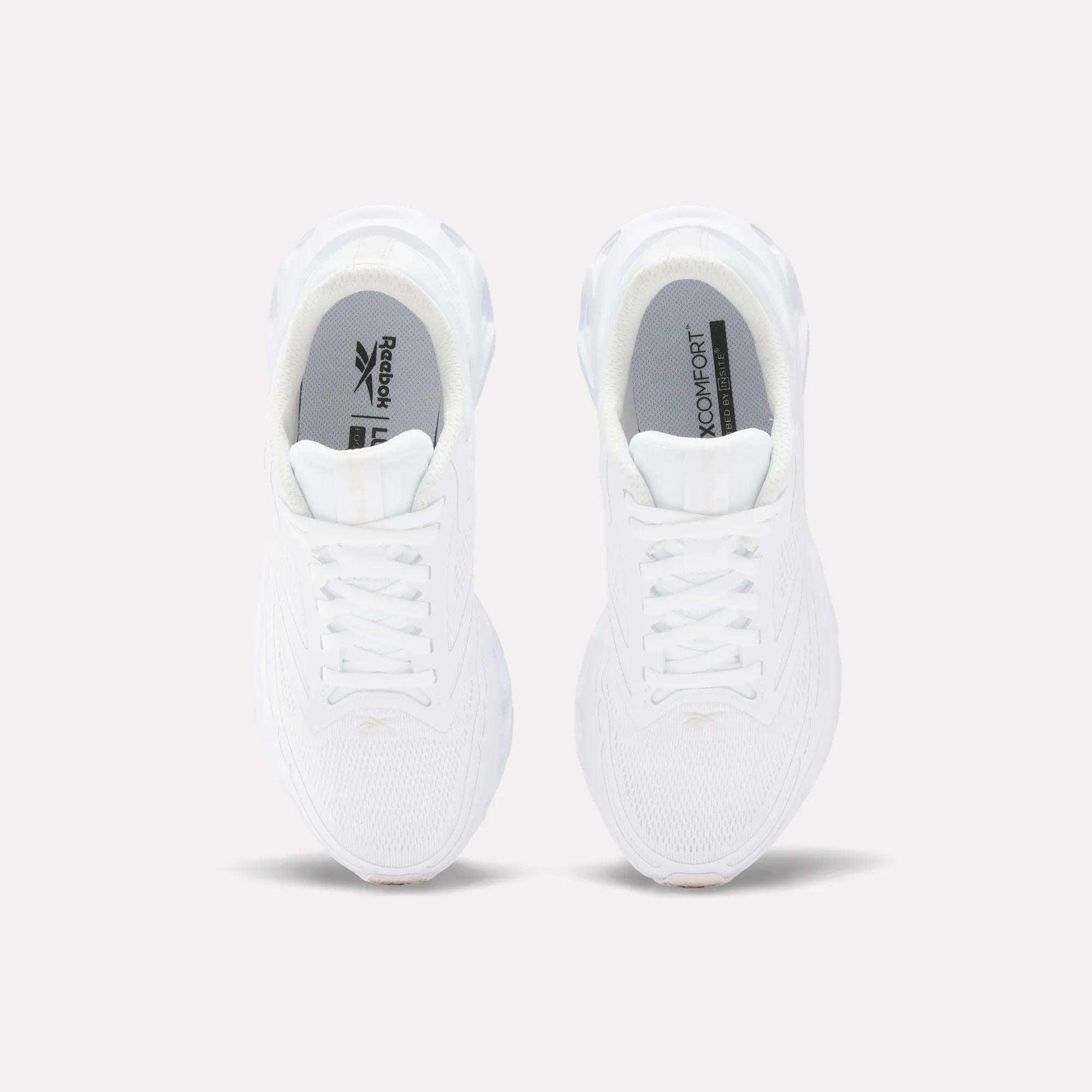 Top view of Reebok Women's Fuel Flex Run Shoes in white with white laces, gray insoles featuring the Reebok logo and "MEMORY TECH" text, and a plush Fuel Flex midsole, set on a plain light background.