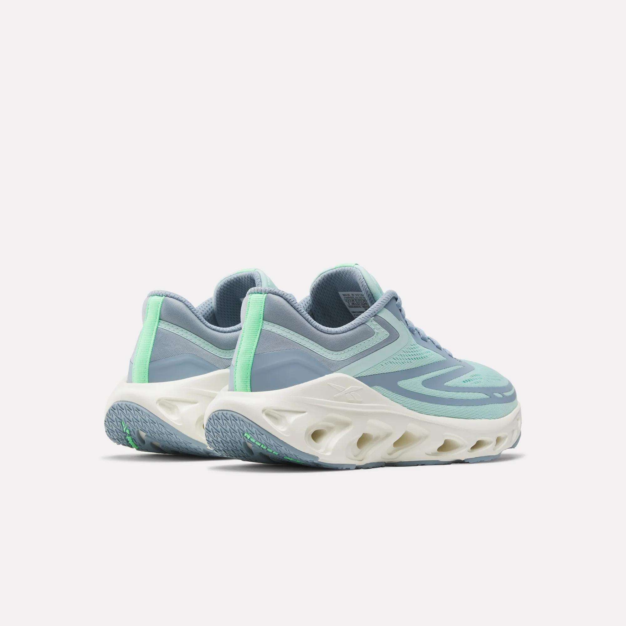 The Reebok Women's Fuel Flex Run Shoes feature a light blue and teal design with mint green accents, white chunky ventilated soles, and a Fuel Flex midsole for lasting comfort, shown on a plain white background.