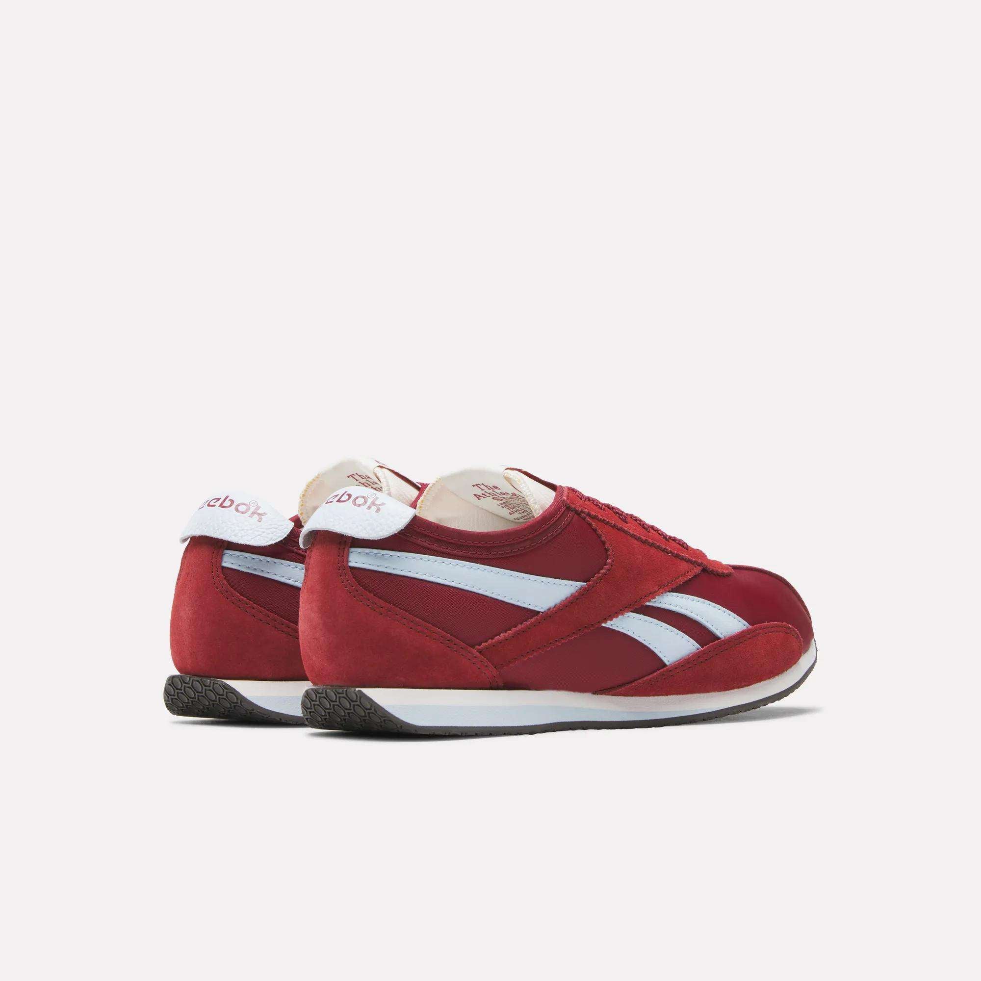 A pair of Reebok R400 Shoes in red with white accents, side stripes, black soles, and the Reebok logo on the heel tabs, showcase classic retro track sneaker style against a plain white background.