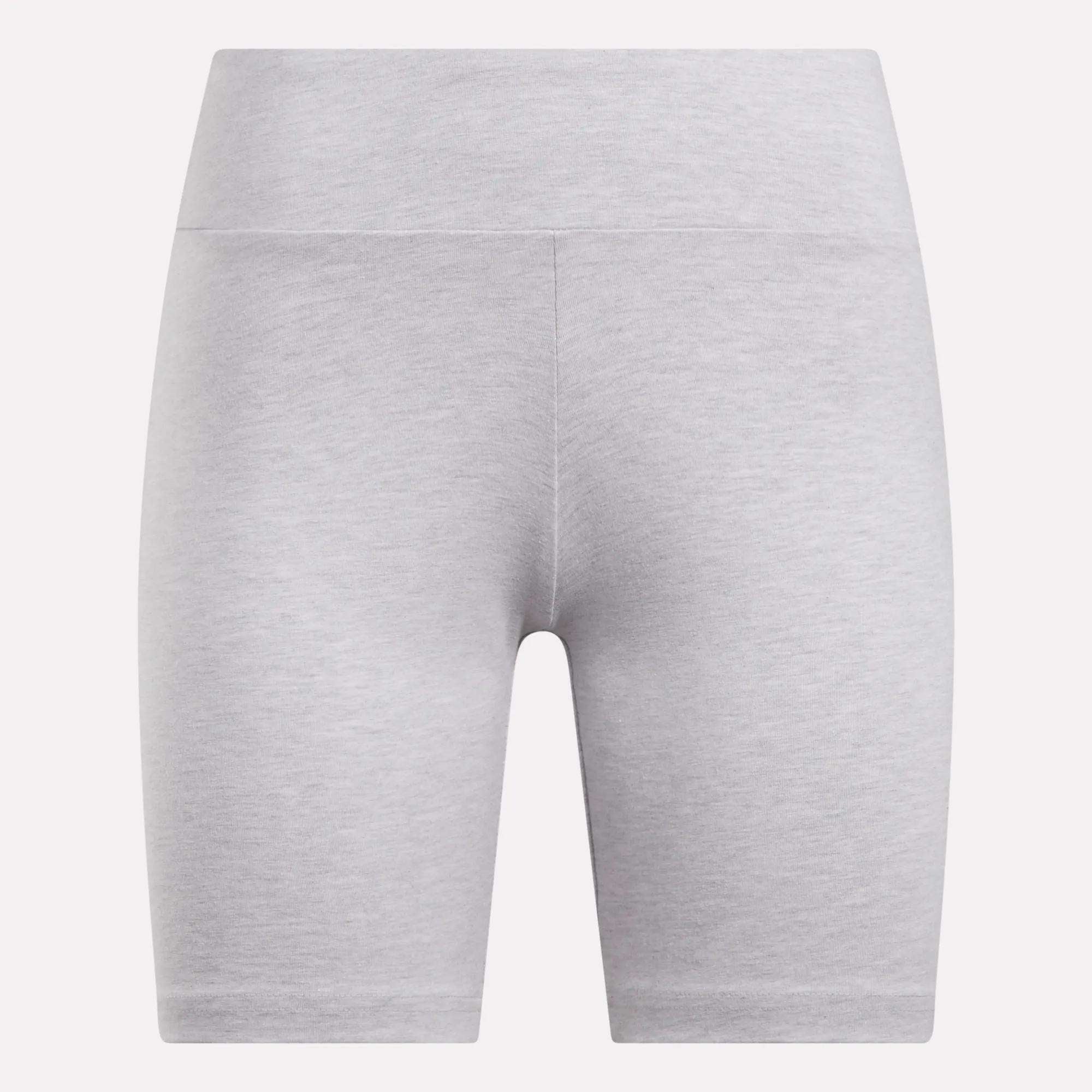 The Reebok Women's Small Logo Cycle Shorts are light gray and high-waisted, crafted from smooth, stretchy fabric with a seamless look against a plain white background. They feature a subtle design with no prominent logos or patterns.