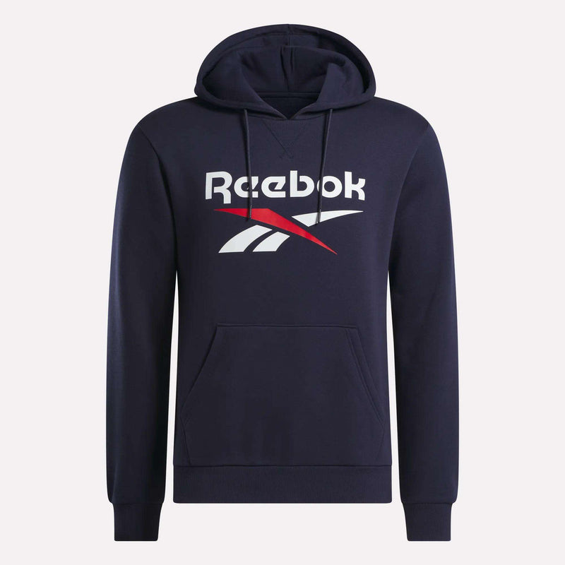 The Men’s Logo Hoodie by Reebok is a navy blue pullover crafted from a soft cotton-blend fleece. It features a front pocket, an adjustable drawstring hood, and the iconic Reebok logo in bold white and red across the chest.