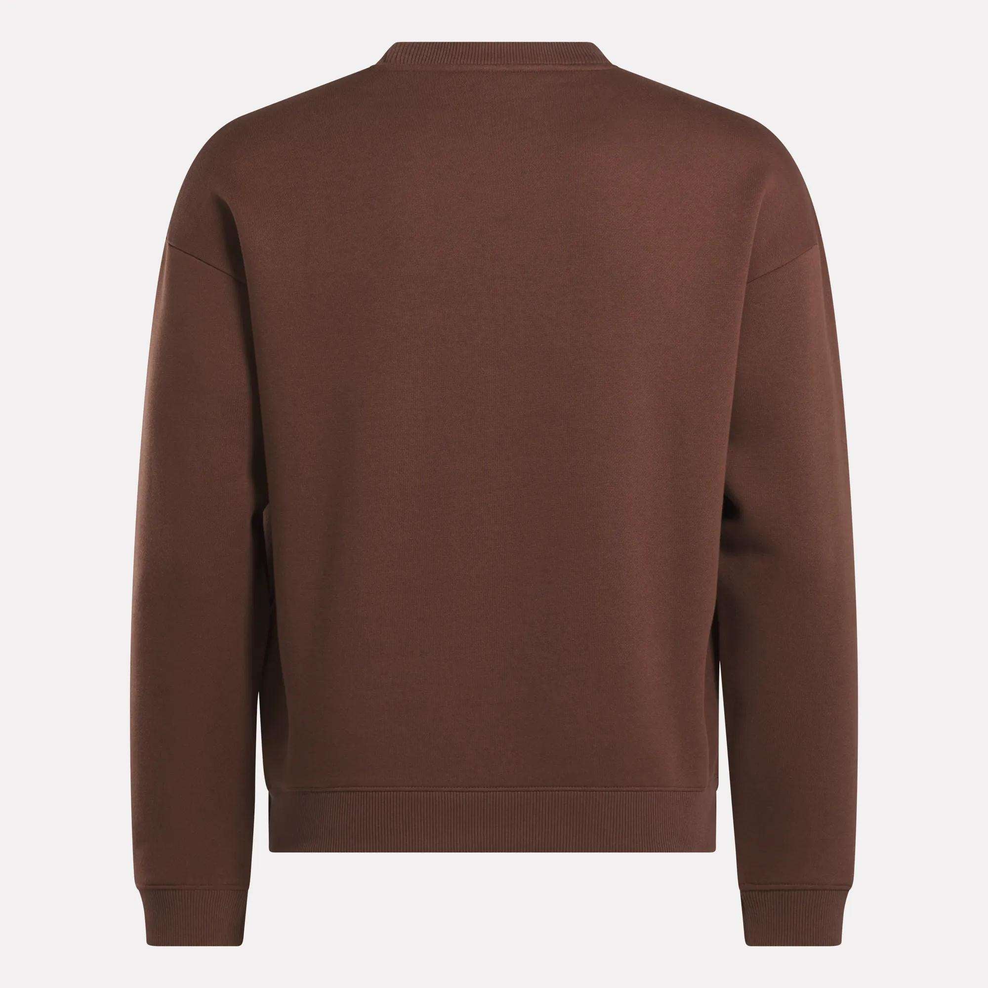 The Men's Varsity Sweatshirt by Reebok, shown from the back in plain brown with ribbed cuffs, waistband, and collar, offers a classic look without graphics or logos—ideal for those seeking timeless Reebok style.