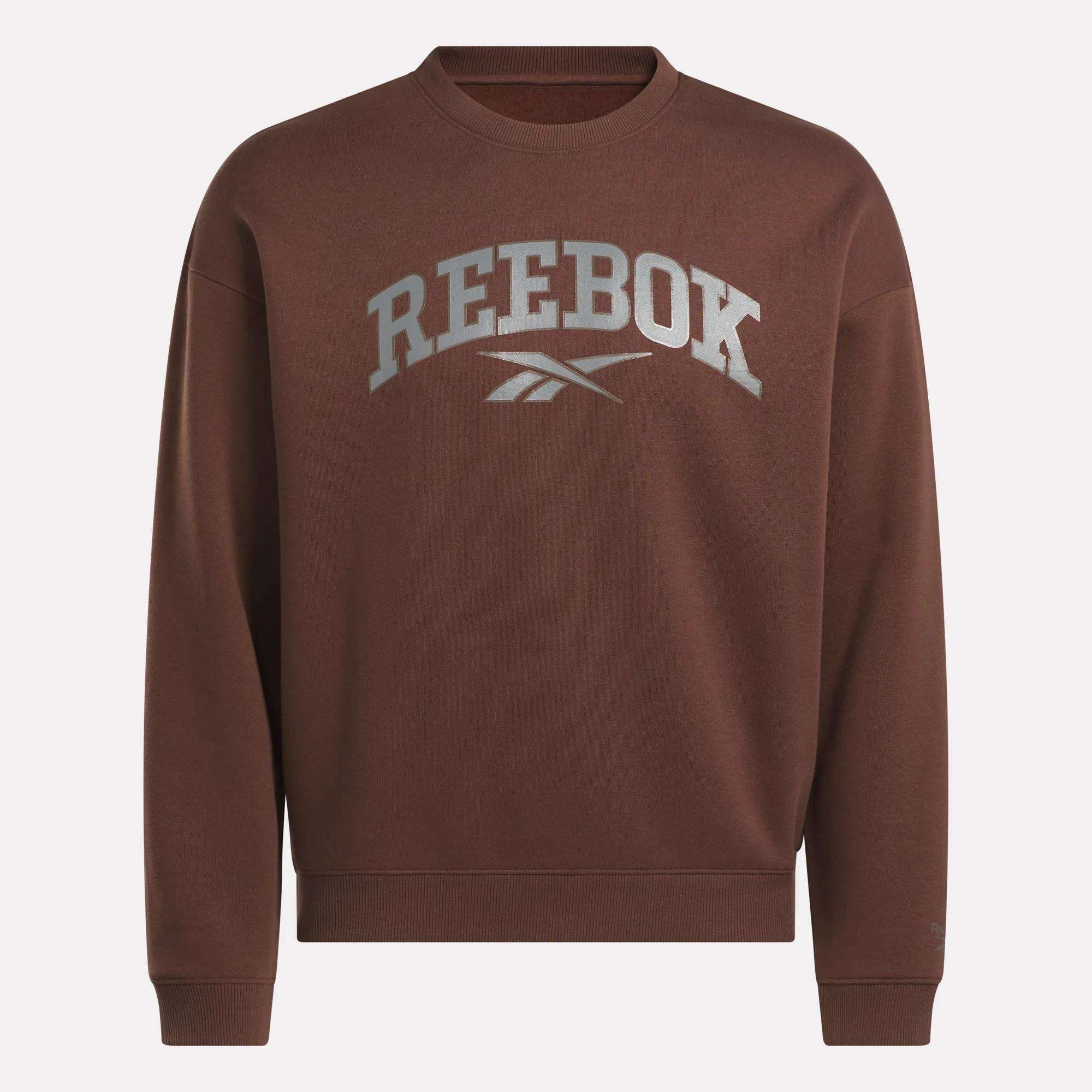 The Reebok Men's Varsity Sweatshirt is brown with REEBOK and the logo in large gray letters on the chest. This crewneck has ribbed cuffs, neckline, and hem for a classic look.