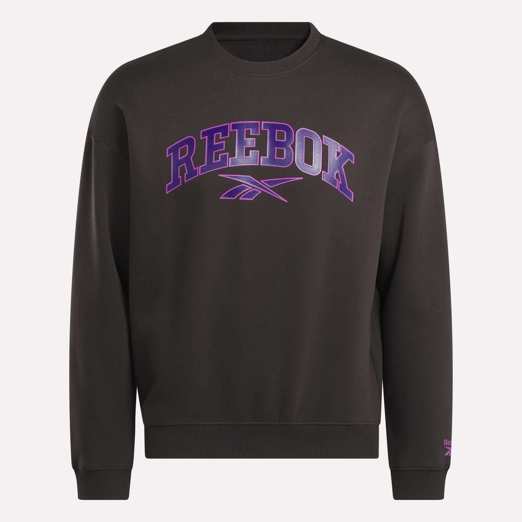 The Reebok Men's Varsity Sweatshirt is a black fleece hoodie featuring large purple "REEBOK" lettering and the logo on the front, designed for comfort.